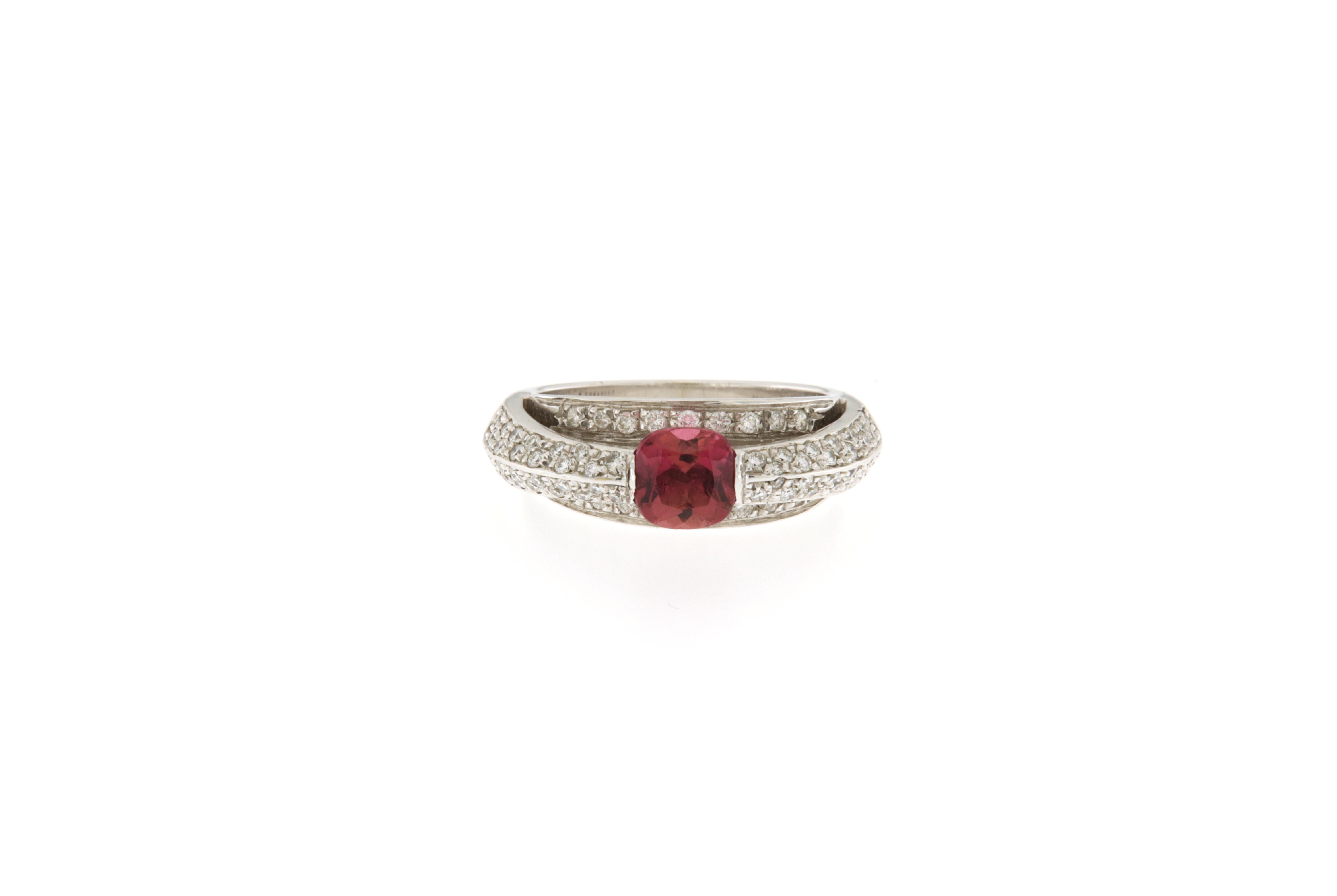 Very nice ring with particular italian design. It is like a ring in another ring with diamonds under and over. The upper ring has got a very beautiful pink tourmaline in the center.