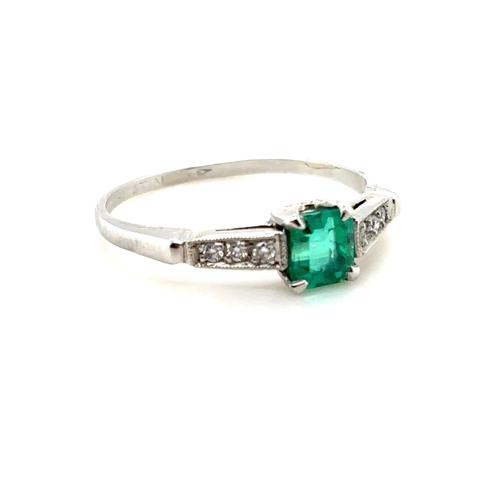 Retro 0.65 carat Columbian emerald and diamond platinum engagement ring. For Sale