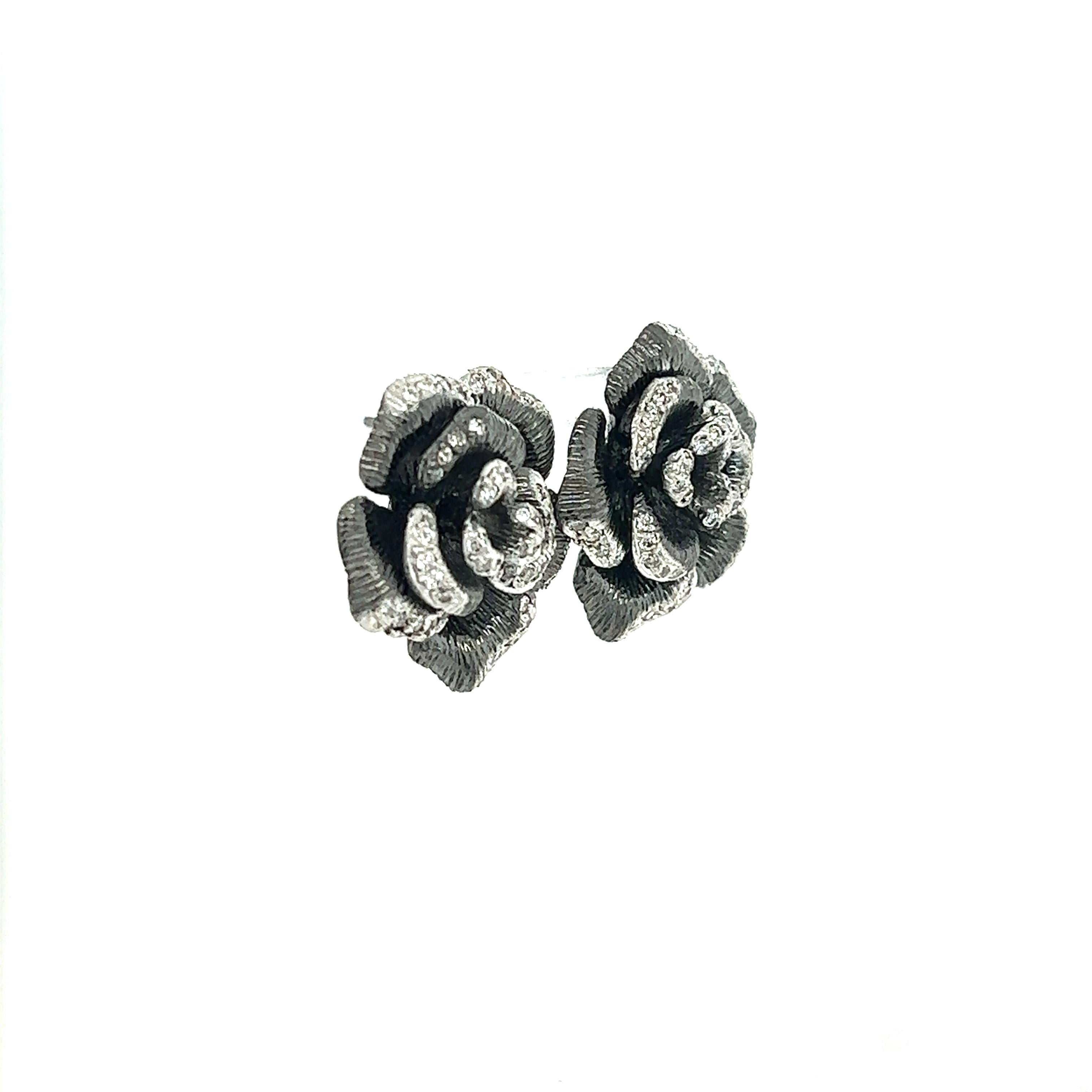 These beautiful flower earrings are set in 18 Karat Gold and has a Black Rhodium finish. 
There are 0.65 carats of Natural Round Cut Diamonds that have a clarity and color of VS-F. 

The earrings have an approximate weight of 11.0 grams. 