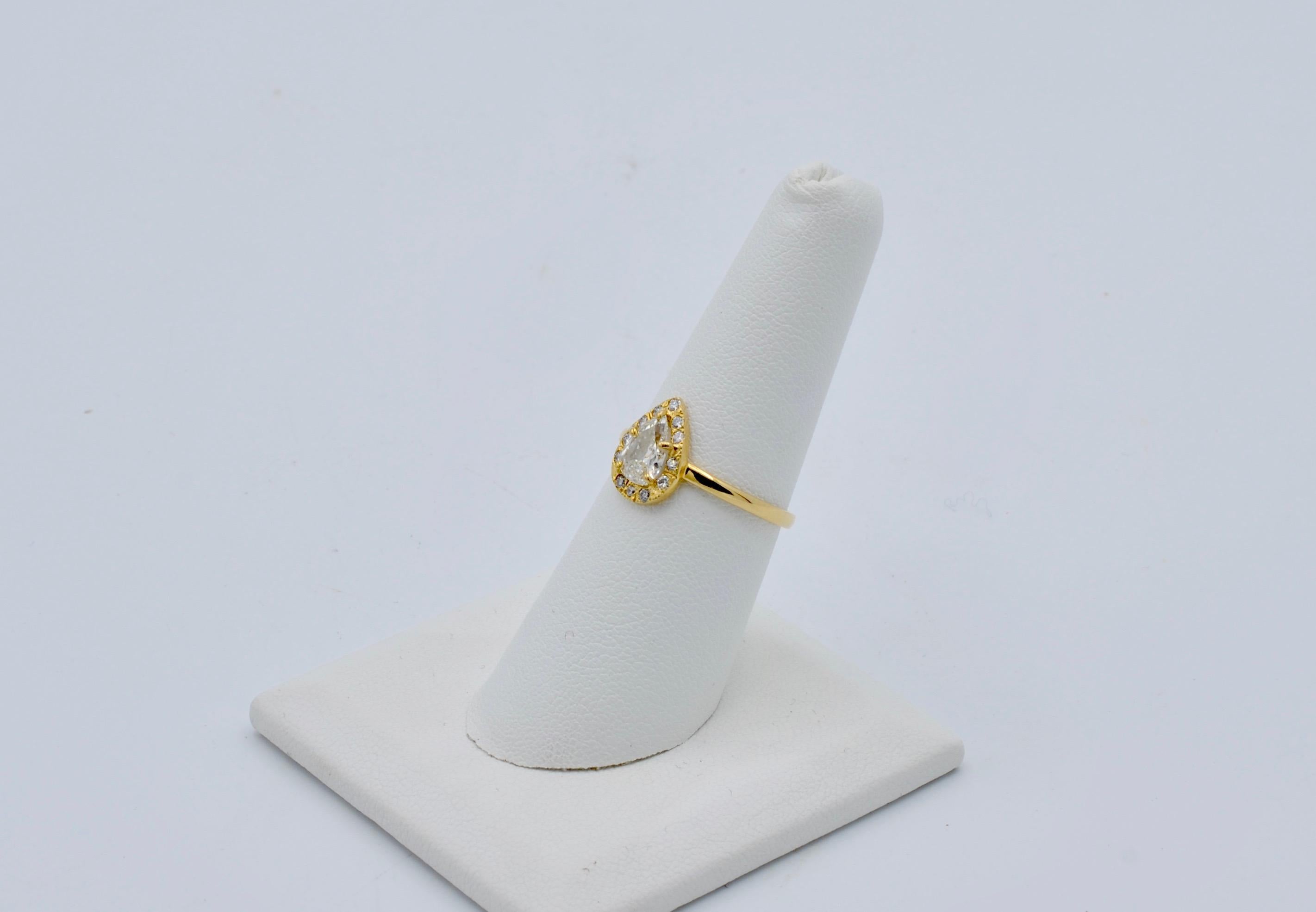 This beautiful 0.65 pear shaped diamond is set in 14k gold with a diamond halo is the perfect symmetry of balanced proportion. The center diamond is SI1 J/K color and is surrounde by 12 brilliant white diamonds measuring 0.18 tw carats. The ring