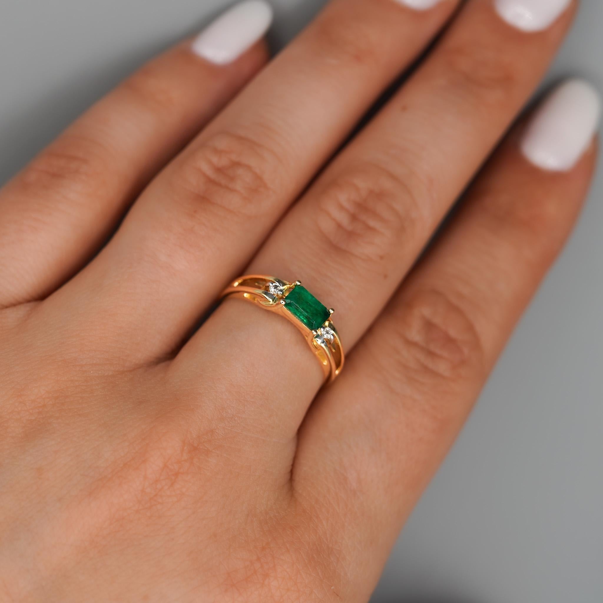 Dainty and slim, a 14K yellow gold ring featuring a vivid deep green emerald in a classic 2 row open gap setting with accent diamonds on each side. It's thin but sturdy 3.6mm band and delicate design make it a timeless everyday