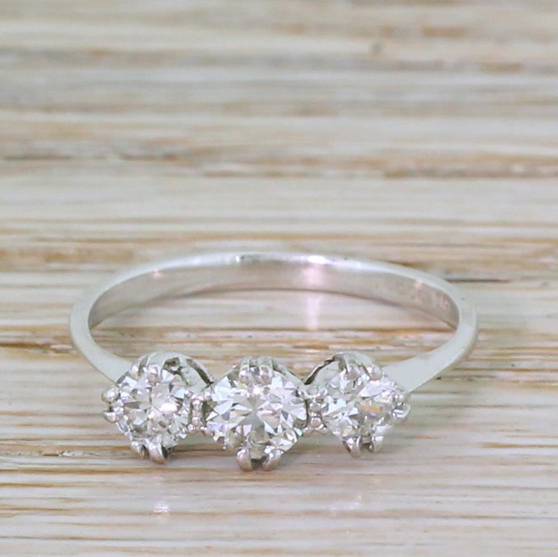 A desperately lovely diamond three stone ring. The trilogy of stones – with a total approximate weight of 0.65 carat – are blindingly white and crackling with fire and brilliance. Each is secured in by four double claws set at compass points in