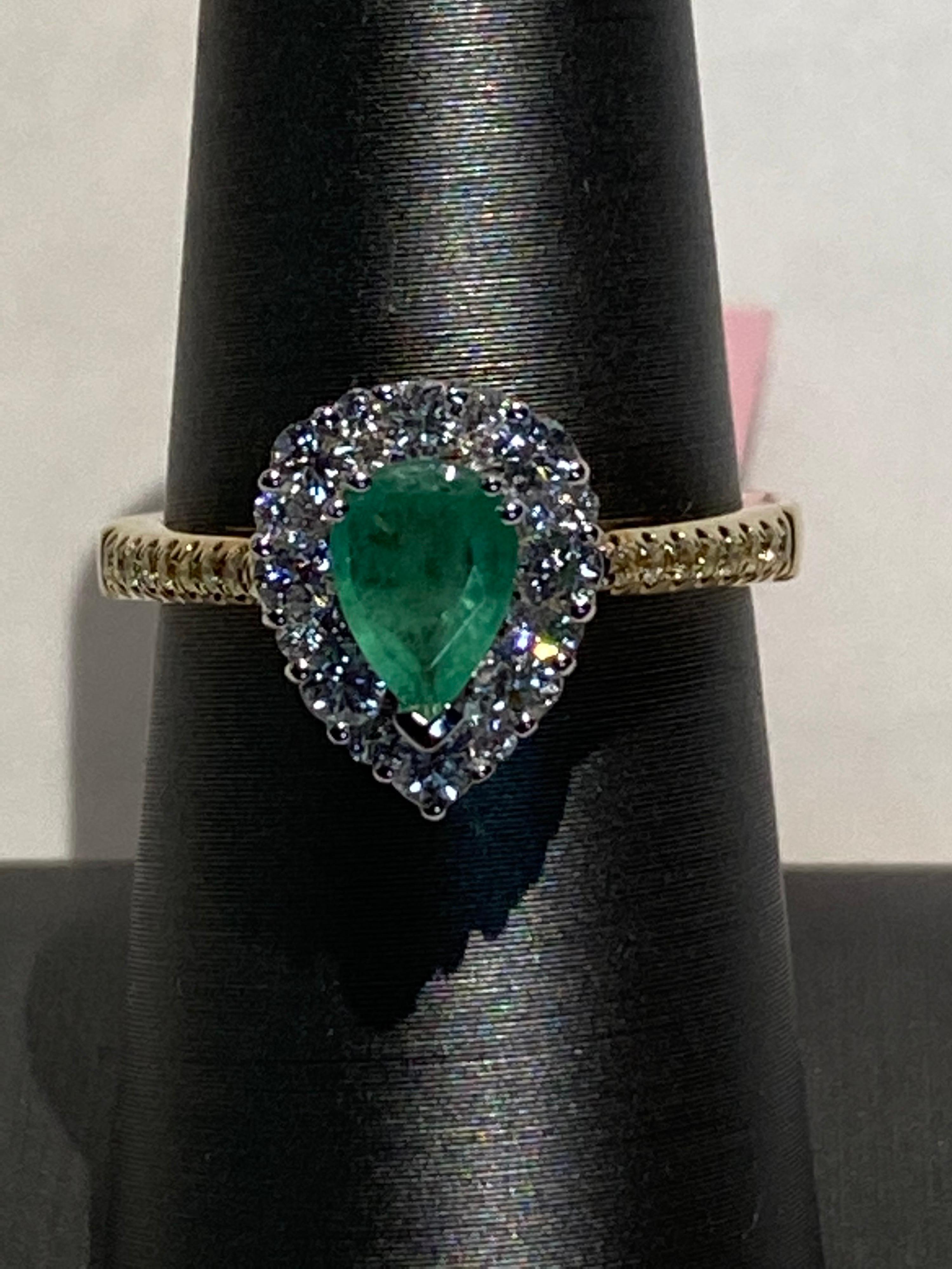 This Pear shaped emerald has a diamond halo set in white gold with a yellow gold band of yellow diamond. Classic style which never goes out of style. 
Emerald: 0.65ct
Yellow Diamond: 0.05ct
White Diamond: 0.45ct
Two Tone Gold: 14K
Size: 7