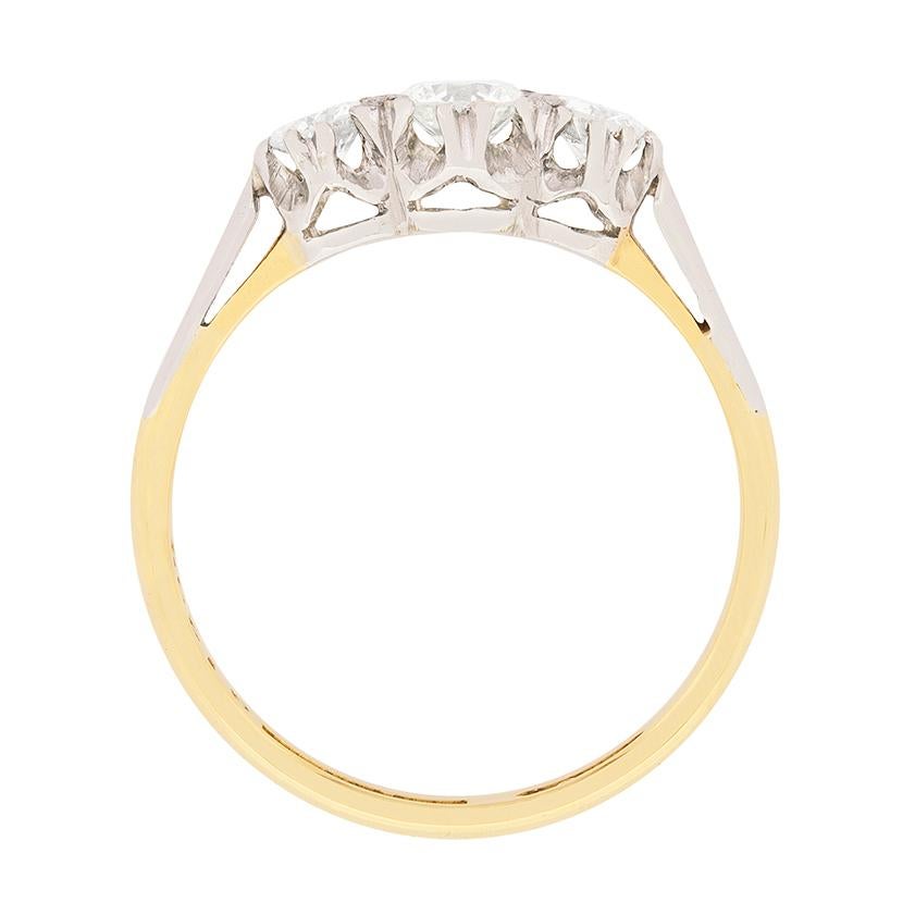 A glittering trio of transitional cut diamonds is the focal point of this three stone diamond engagement ring, which dates from the 1940s. These vintage stones, totalling 0.65 carats, are claw set in platinum between raised platinum shoulders atop