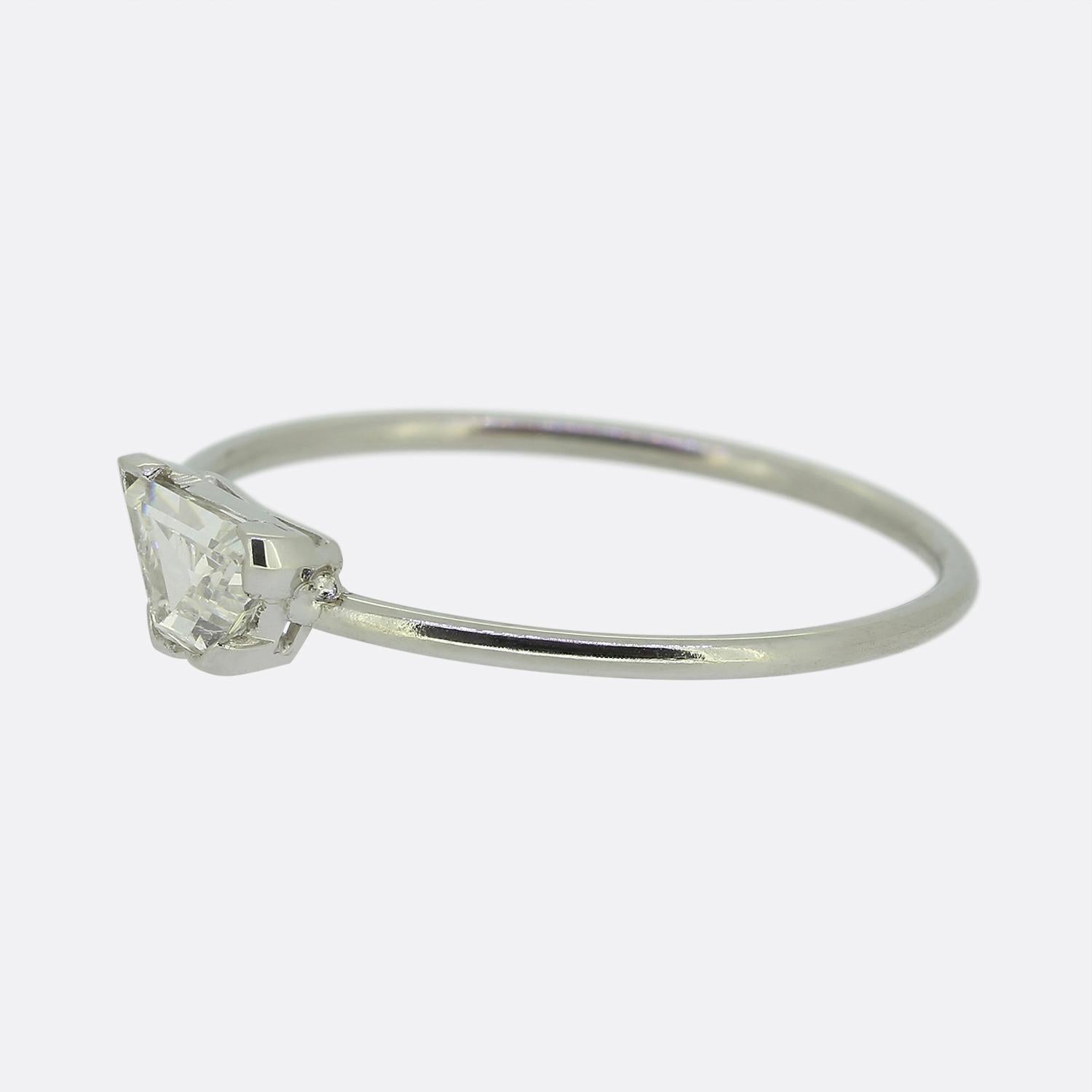 Hier haben wir einen raffinierten Solitärring, der einen fesselnden Diamanten im Trapezschliff präsentiert. Elegant auf einem schmalen Platinband gefasst, wird dieser einsame Stein von einer markanten Zackenfassung gehalten, die seinen geometrischen