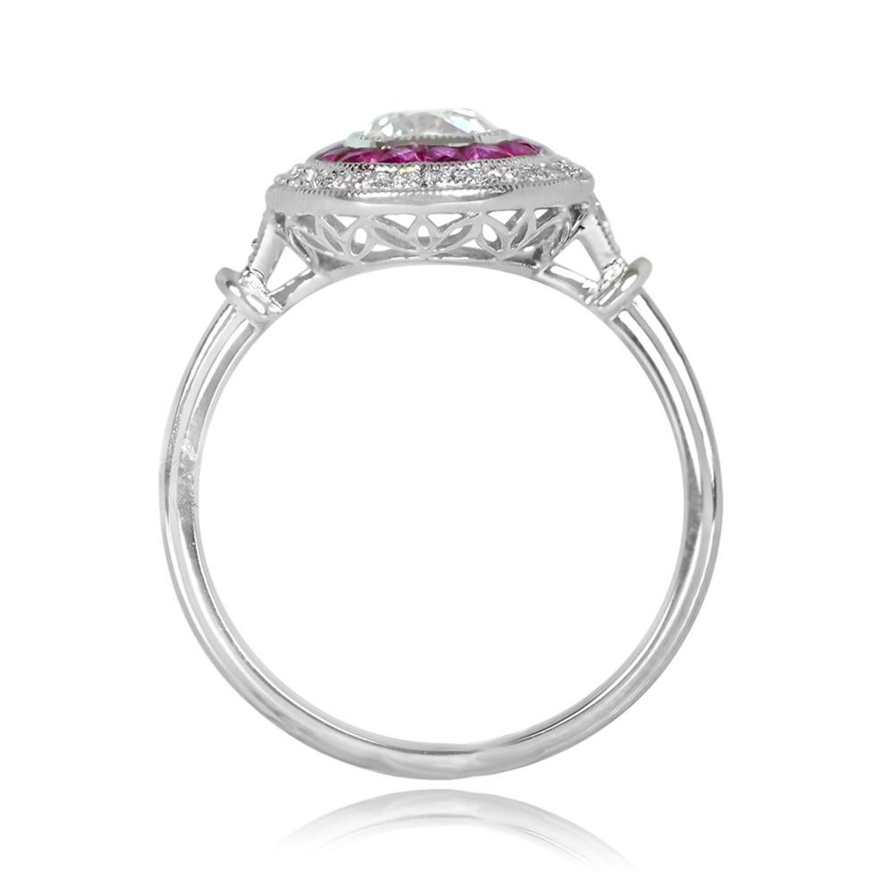 A captivating double halo engagement ring boasts an antique cushion cut diamond, about 0.65 carats, J color, and VS1 clarity. The center gem is embraced by French-cut natural red rubies and encircled by a halo of diamonds, forming an elegant oval