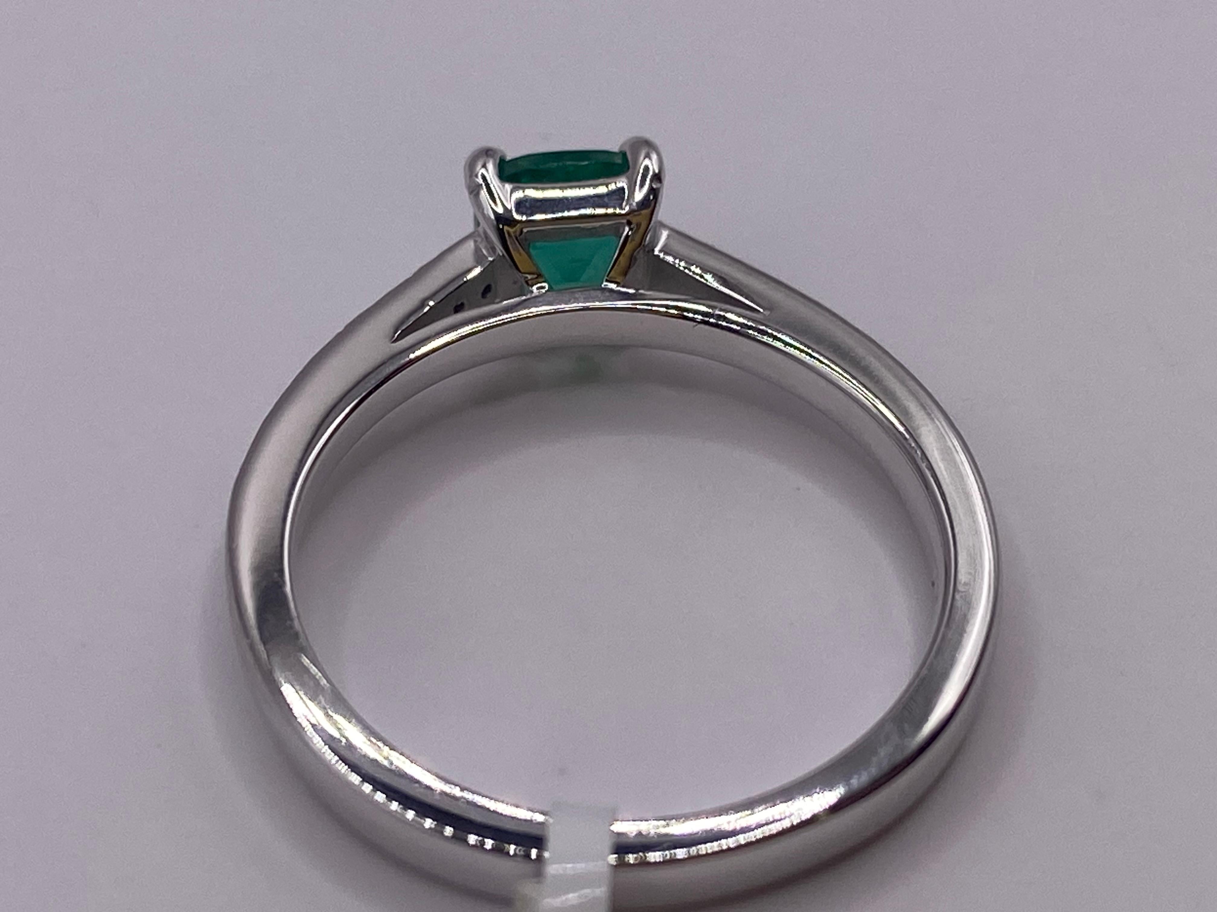 Metal: 14KT White Gold
Finger Size: 6.5
(Ring is size 6.5, but is sizable upon request)

Number of Cushion Cut Emeralds: 1
Carat Weight: 0.58ctw
Stone Size: 5.25 x 5.25mm
Prong Set

Number of Diamonds: 18
Carat Weight: 0.07ctw
Pave Set