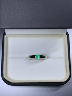 0.65ct Emerald green wedding ring in 18k white gold.