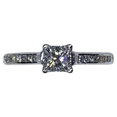 Anillo de compromiso de diamante princesa de 0,65 ct con halo de diamantes en oro blanco de 18k.