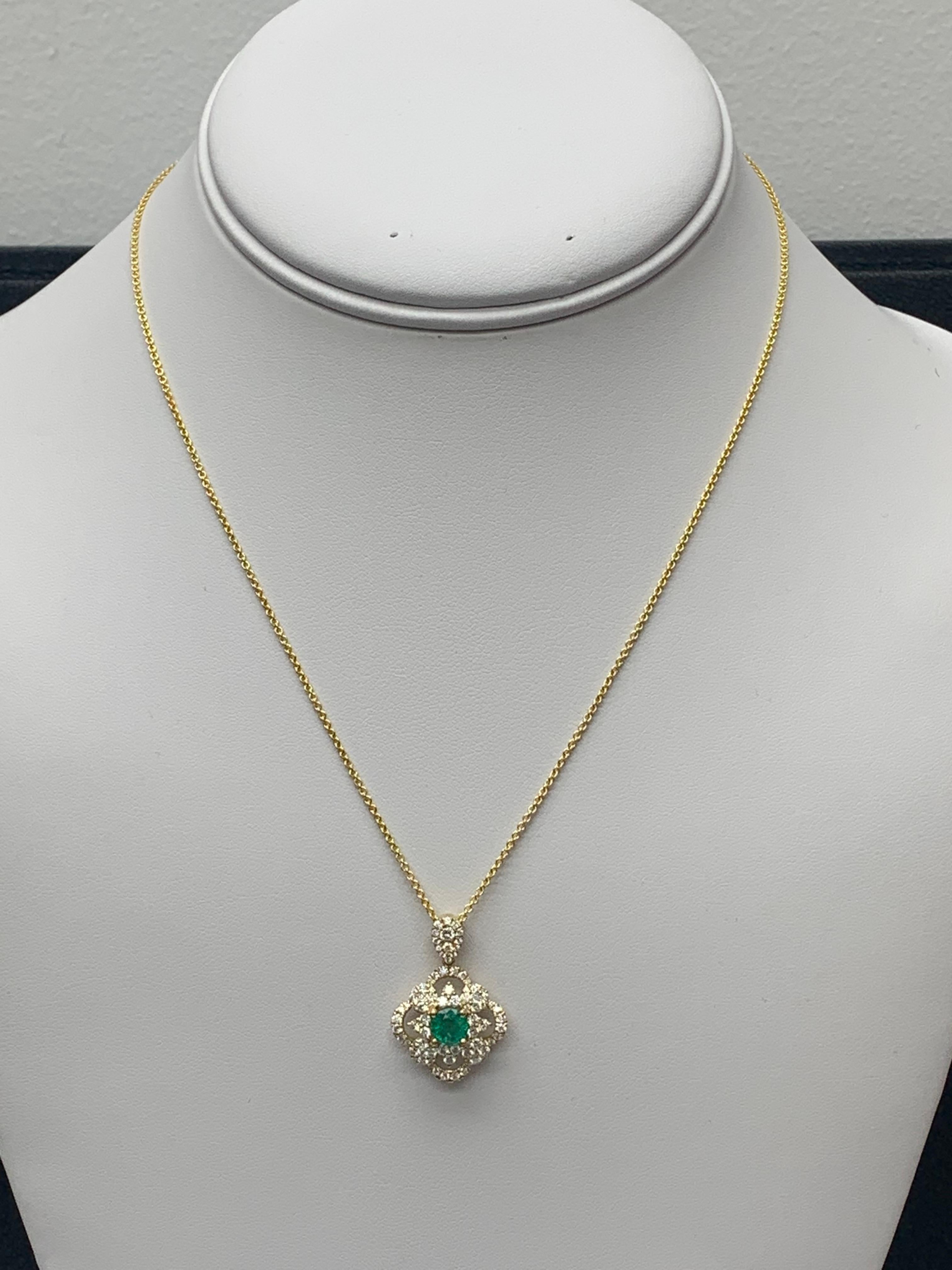 A Classic pendant necklace Set with a round green emerald center stone accented by 76 accent brilliant diamonds  in an open work design. The weight of diamonds and emerald is 1.03 carats and 0.67 carats respectively. 16