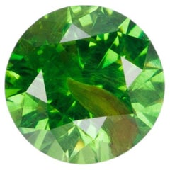 0.67 ct, Vivid green faceted Russian demantoid with byssolite inclusioms