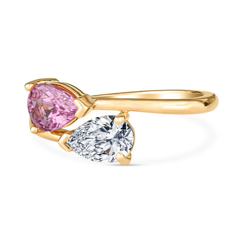 This toi et moi ring features a 0.67ct pear shaped natural diamond and a 0.97ct pear shape pink sapphire set in 14 karat yellow gold. It is a size 7 but can be resized upon request. The toi et moi ring is a very historic ring setting and symbolizes