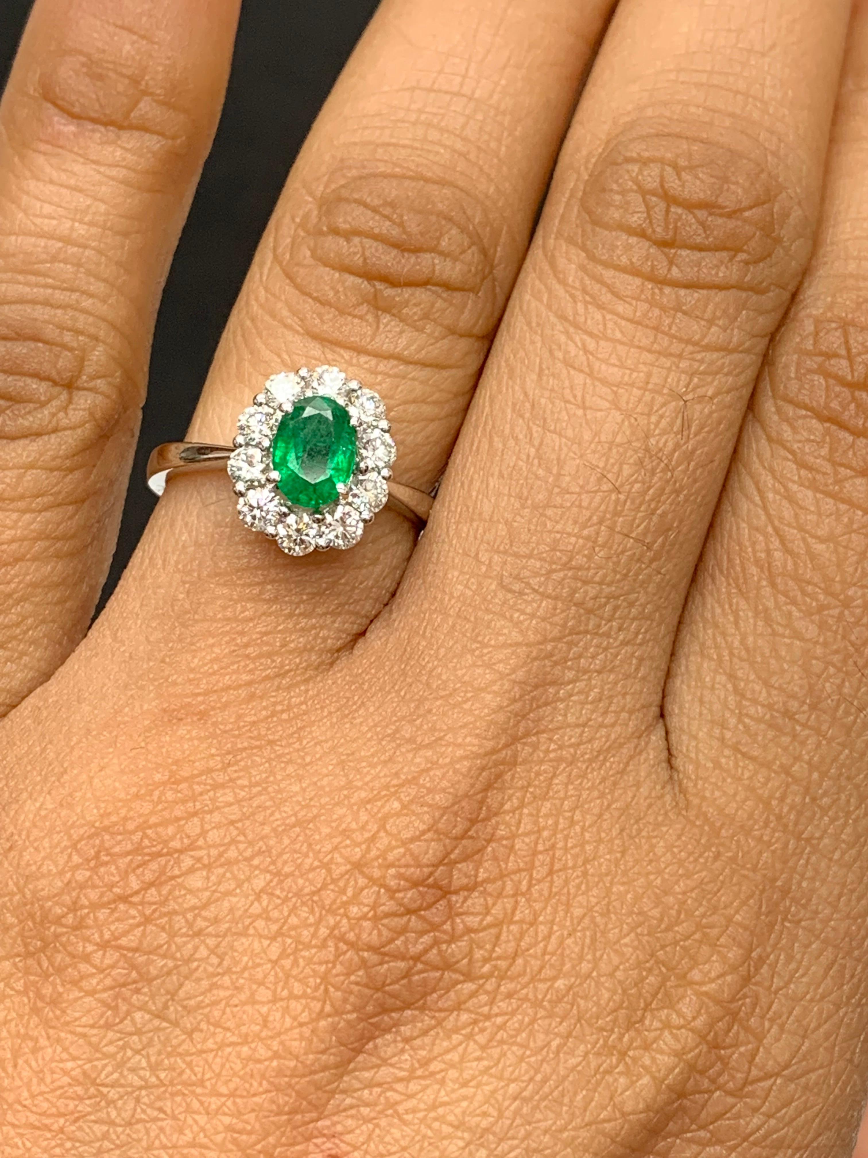 A stunning well-crafted engagement ring showcasing a 0.68-carat oval cut emerald. Flanking the center diamond are perfectly matched brilliant cut 10 diamonds weighing 0.74 carats in total, set in a polished 18K White Gold mounting. Handcrafted in