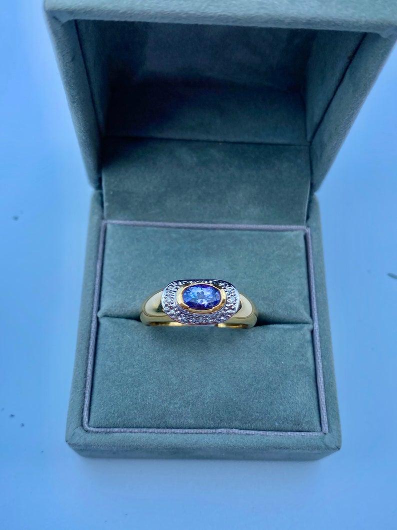 Centering a 0.68 Carat Tanzanite, accented by Round-Brilliant Diamonds, and set in 14K Yellow Gold, this Vintage Engagement Ring is a distinct choice for the unique couple.

Details:
✔ Stone: Tanzanite
✔ Center-Stone Weight: 0.68 carats
✔ Stone Cut: