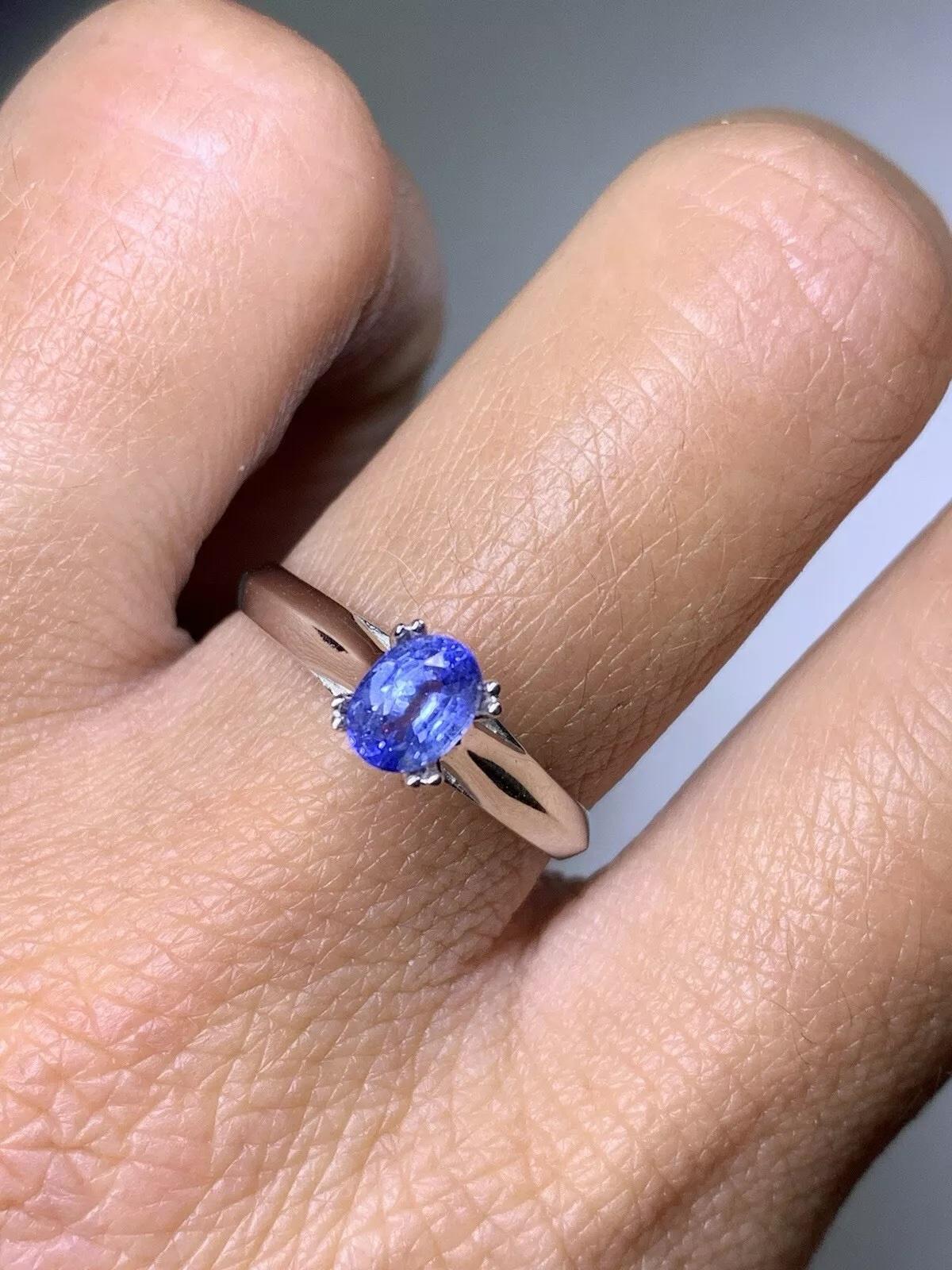 Cette magnifique bague de fiançailles présente un saphir bleu serti en solitaire sur un anneau en or blanc 18ct. La pierre de forme ovale présente une création naturelle et une excellente qualité de taille, ce qui en fait un véritable objet