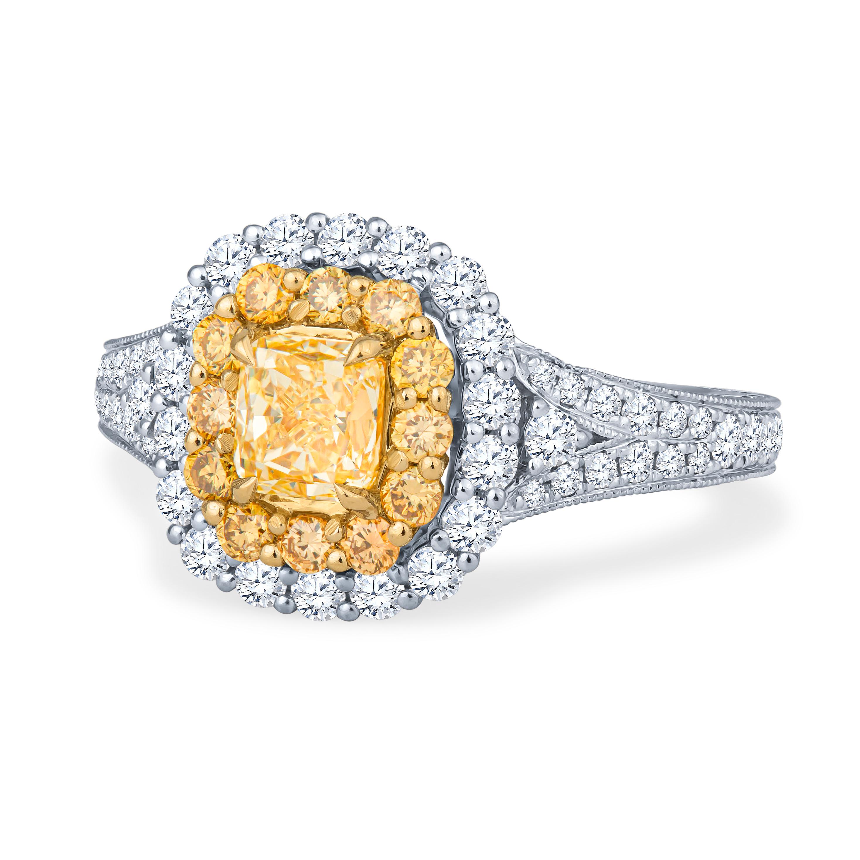 This big, beautiful ring features a natural 0.68ct radiant cut diamond, which is a fancy yellow VS2, set in 18kt white and yellow gold cushion shaped double halo, split shank. Accompanying the main stone is 0.90ct total weight in yellow and white