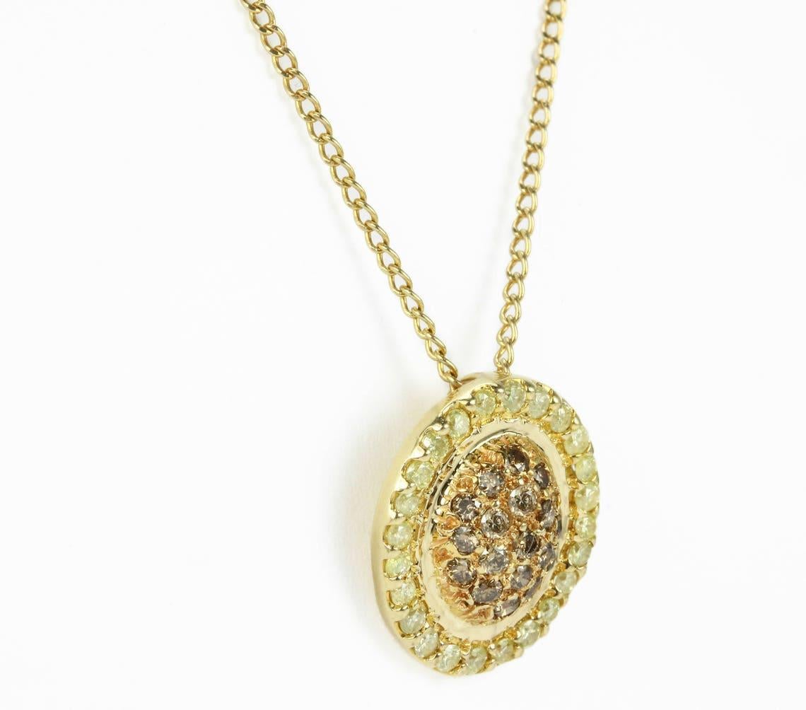 Displayed is a radiant fancy yellow & champagne diamond necklace. This is a perfect piece with a gorgeous colored stones. The center champagne diamonds are pave set in a rosy gold creating beautiful contrast between the colors. Ever so beautiful, a