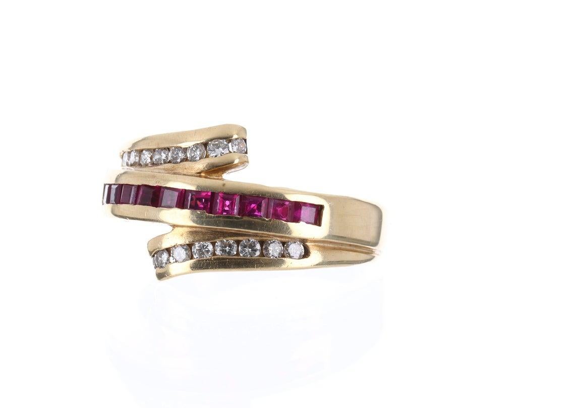Displayed is a romantic ruby and diamond ring. Created in solid 14 karat gold, this ring showcases numerous princess cut ruby's in a channel setting. These gemstone have exceptional vibrant red color that must be seen in person to be fully