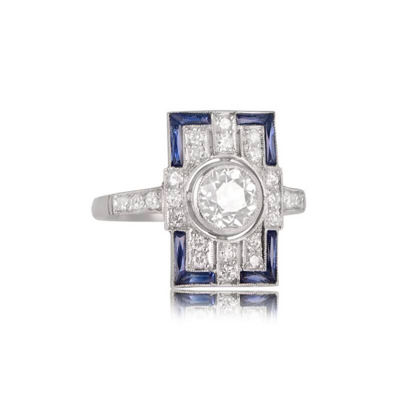 A geometric Art Deco-style ring showcasing a vibrant old European cut diamond at its heart, weighing around 0.69 carats, with a K color and VS2 clarity. A captivating pattern of Old European diamonds graces the north-south axis of the plaque, while