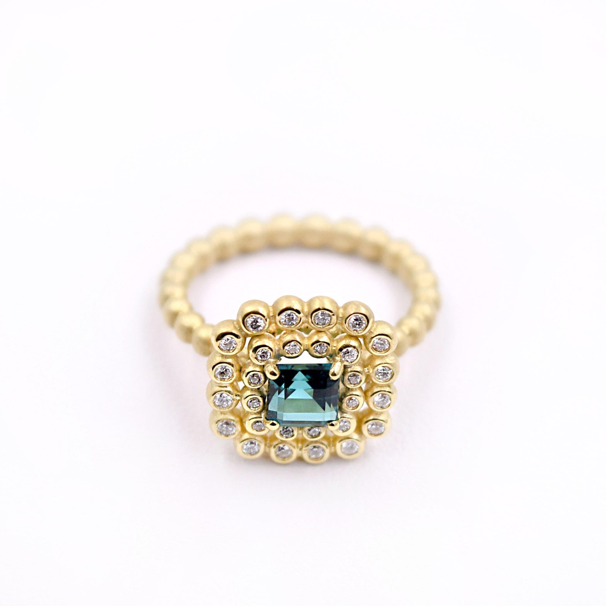 This one-of-a-kind cocktail ring is designed and handcrafted by Suzy Landa in New York.
Its square 0.7ct indicolite tourmaline is set in a basket setting and surrounded by a double row of 0.28ct diamond-set beads. 
Size of the ring is 5 and can be