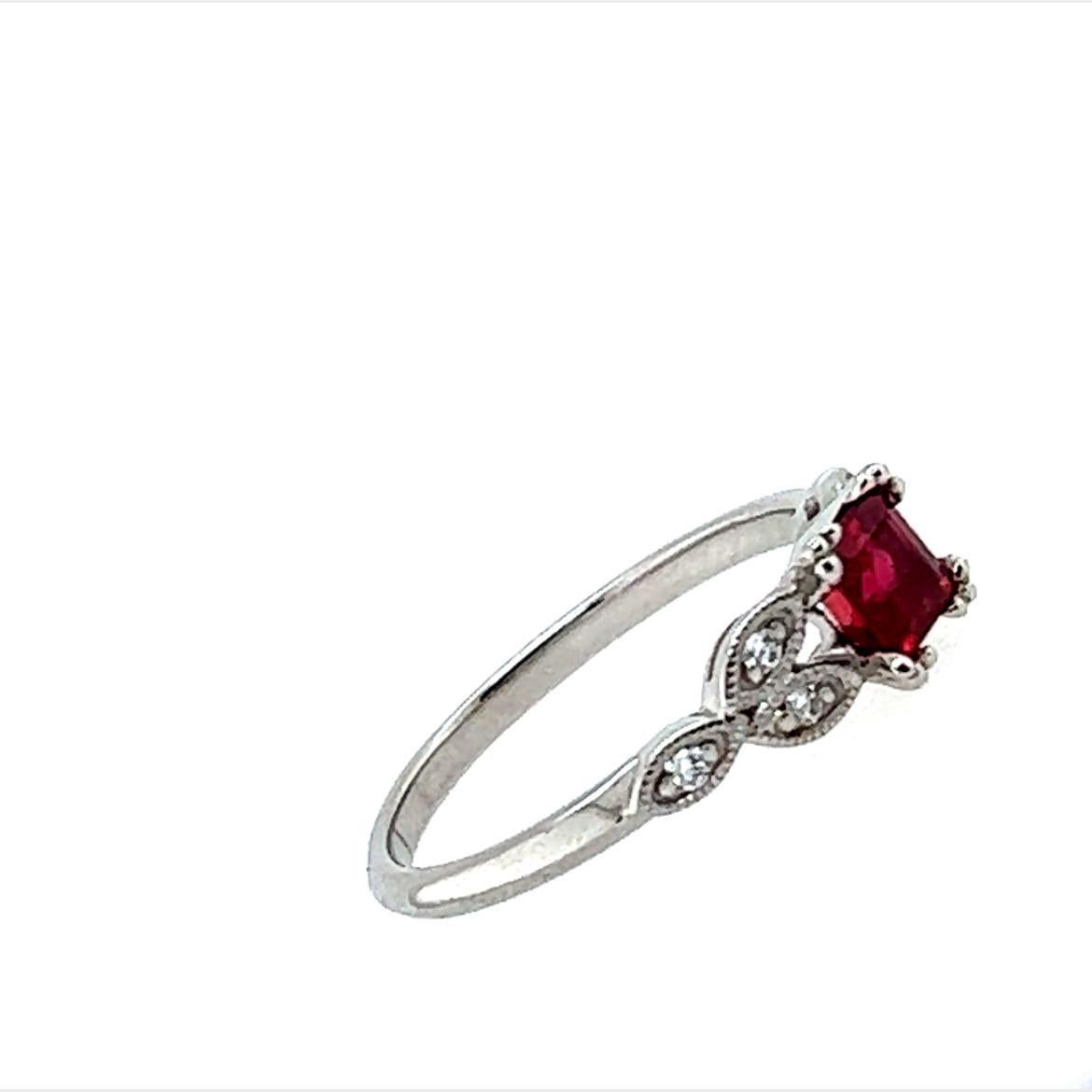 Made of a stunning princess cut blood red Ruby weighing 0.70ct, the centre stone of this beautiful masterpiece is elevated by scintillating Diamonds weighing 0.06cts set in 18K White Gold. The elegant design of this dainty ring in which the diamonds