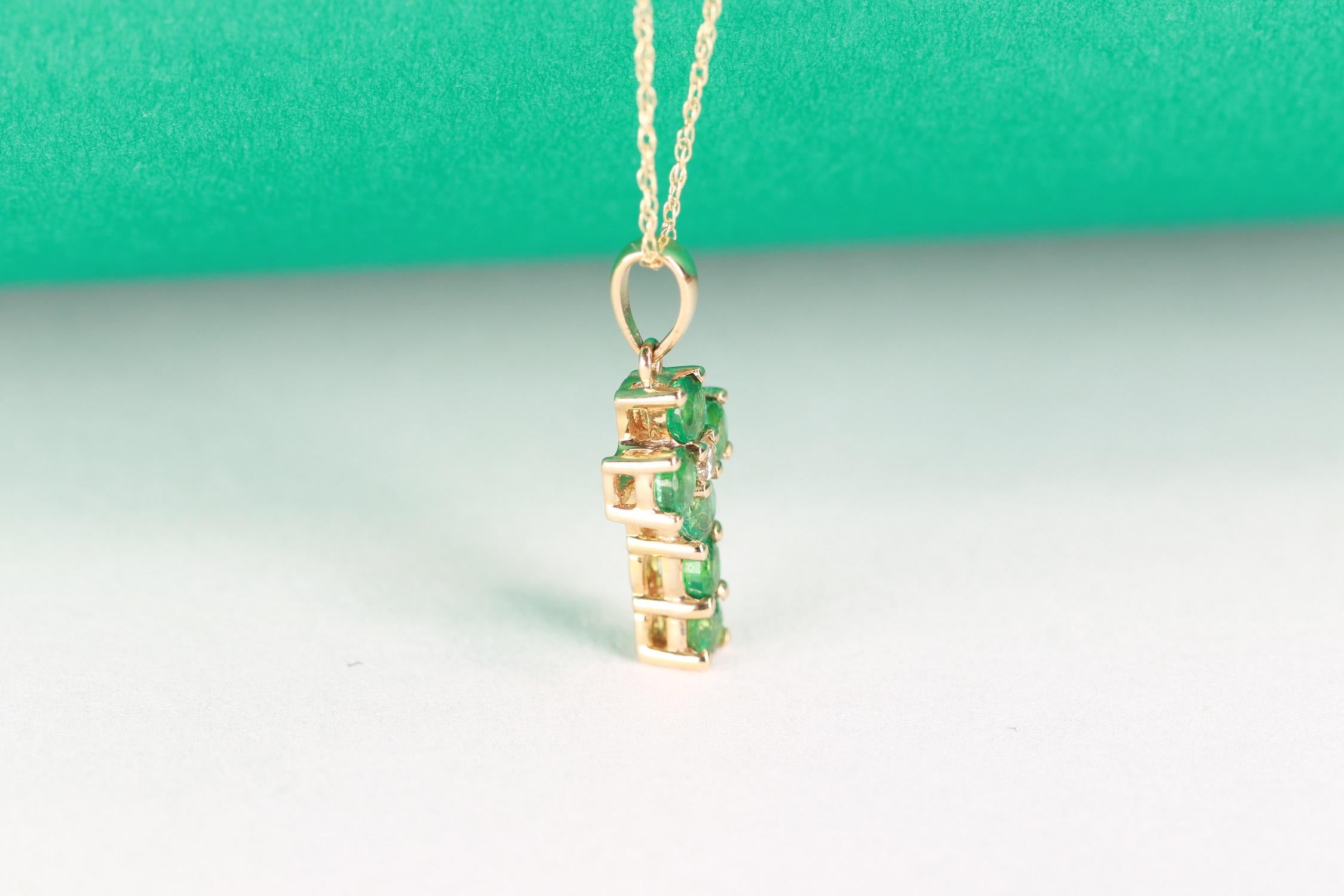 Faites preuve d'élégance avec ce pendentif en or jaune 10 carats de Gin and Grace. Ce pendentif est composé d'émeraudes (6 pièces) de 3,0 mm, taillées en rond et serties à l'emporte-pièce, de 0,7 carat et de diamants blancs (1 pièce), taillés en