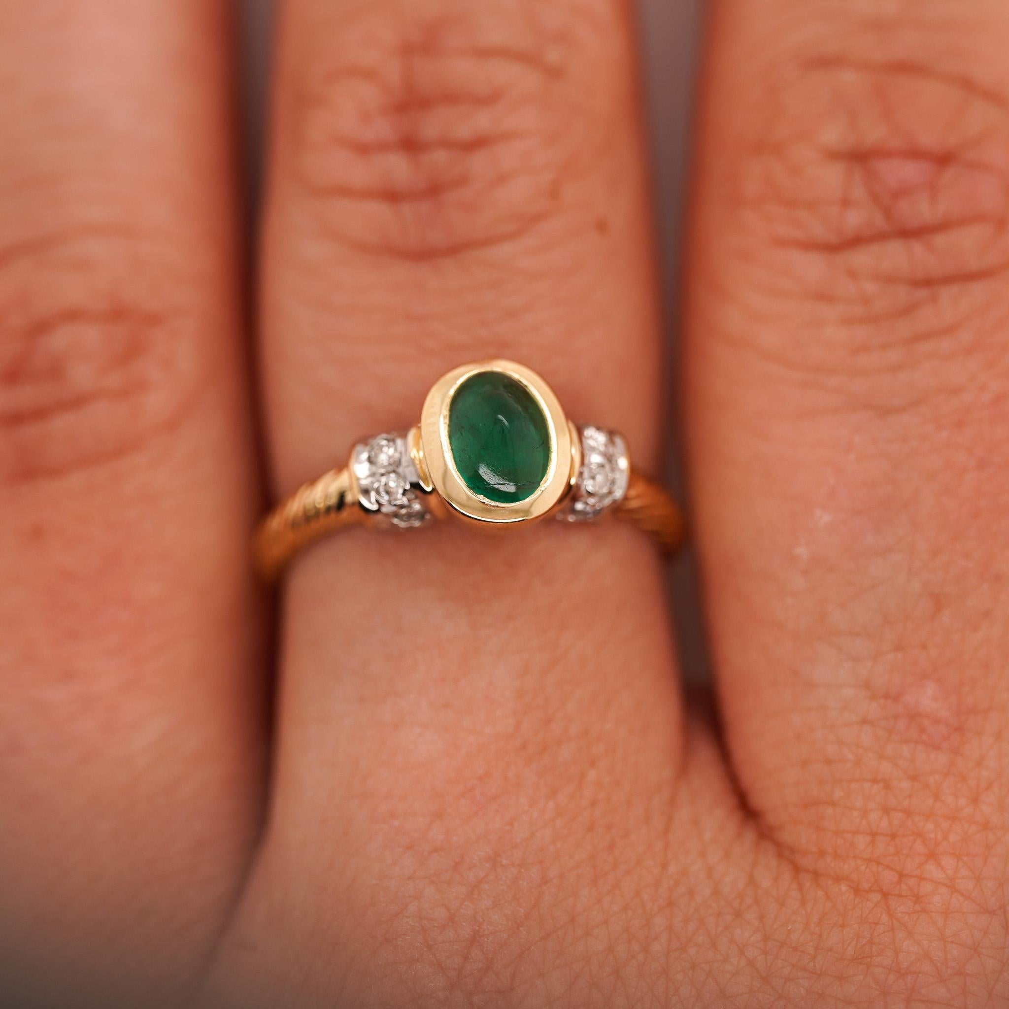 0.70 carat emerald cabochon cut with diamond accents in 14K yellow gold bezel setting and rope style shank ring. A classic vintage piece with a smooth green cabochon and polished detailing. Ring size 7, adjustable.

Details:
Item Type: Bezel