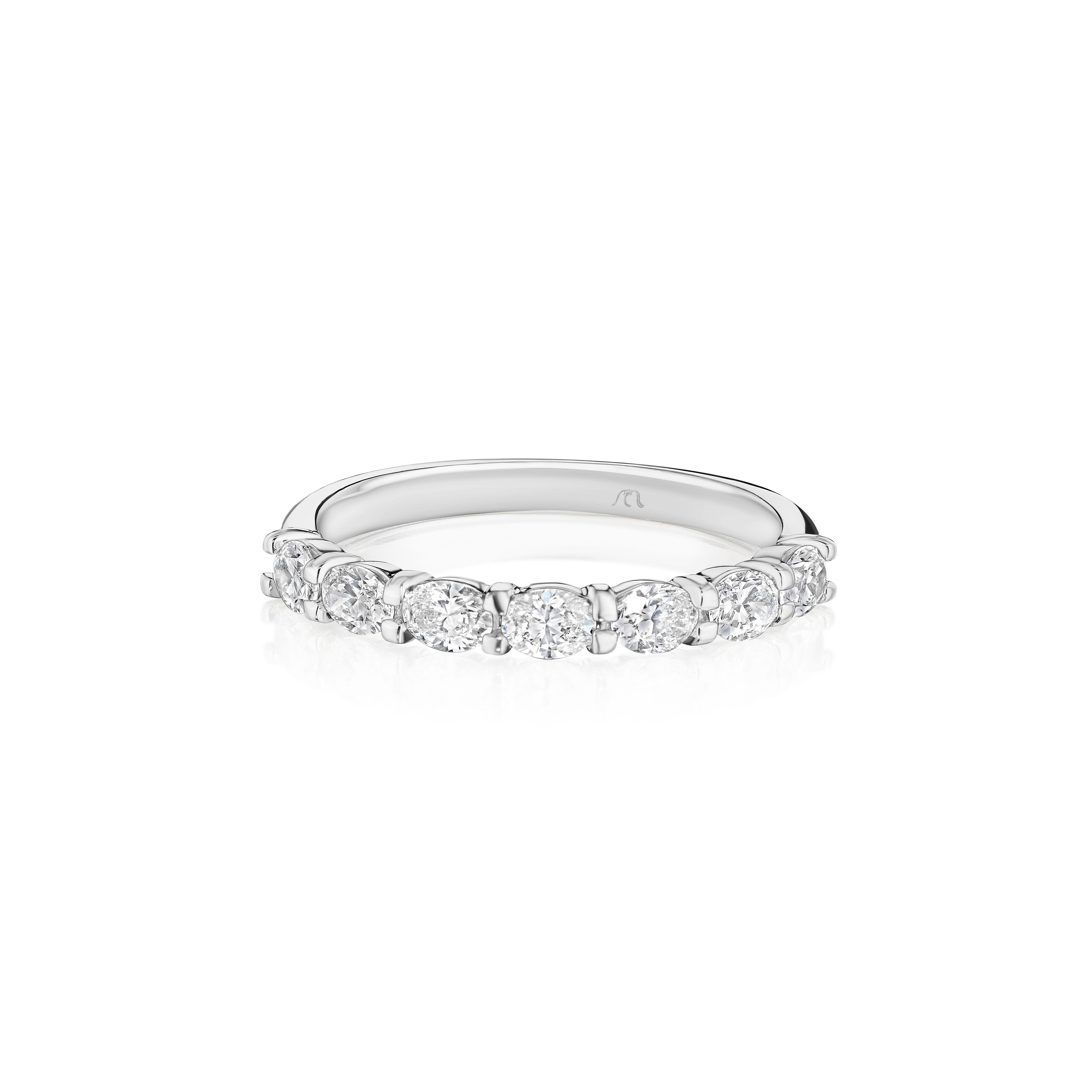 • Crafted in 18KT gold, this band is made with 7 horizontally set oval cut diamonds, and has a combining total weight of approximately 0.70 carats. The diamonds are set into a shared prong cup setting. Worn beautifully on its own or stacked. A