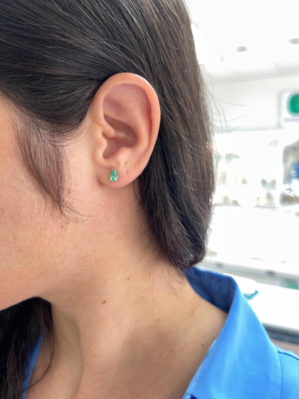 Elevate your style with our exquisite emerald stud earrings, a unique pair that celebrates the finest Colombian emeralds. With a total of 0.70 carats, these pear-cut gems exhibit a mesmerizing medium green color, transparent clarity, and exceptional