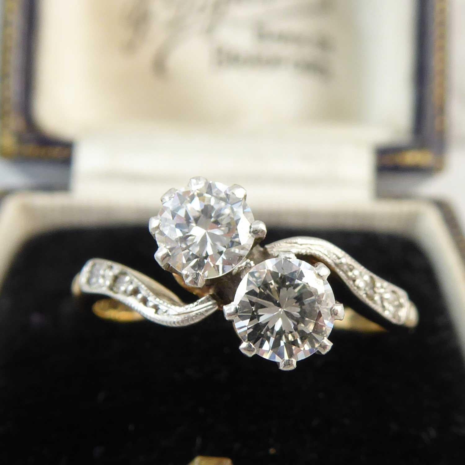 Such a sweet diamond two stone ring set with two brilliant cut diamonds, one measuring 4.60mm x 2.57mm deep approx. and one measuring 4.64mm x 2.67mm deep.  Each diamond is held in an eight claw basket style setting to an asymmetric band with