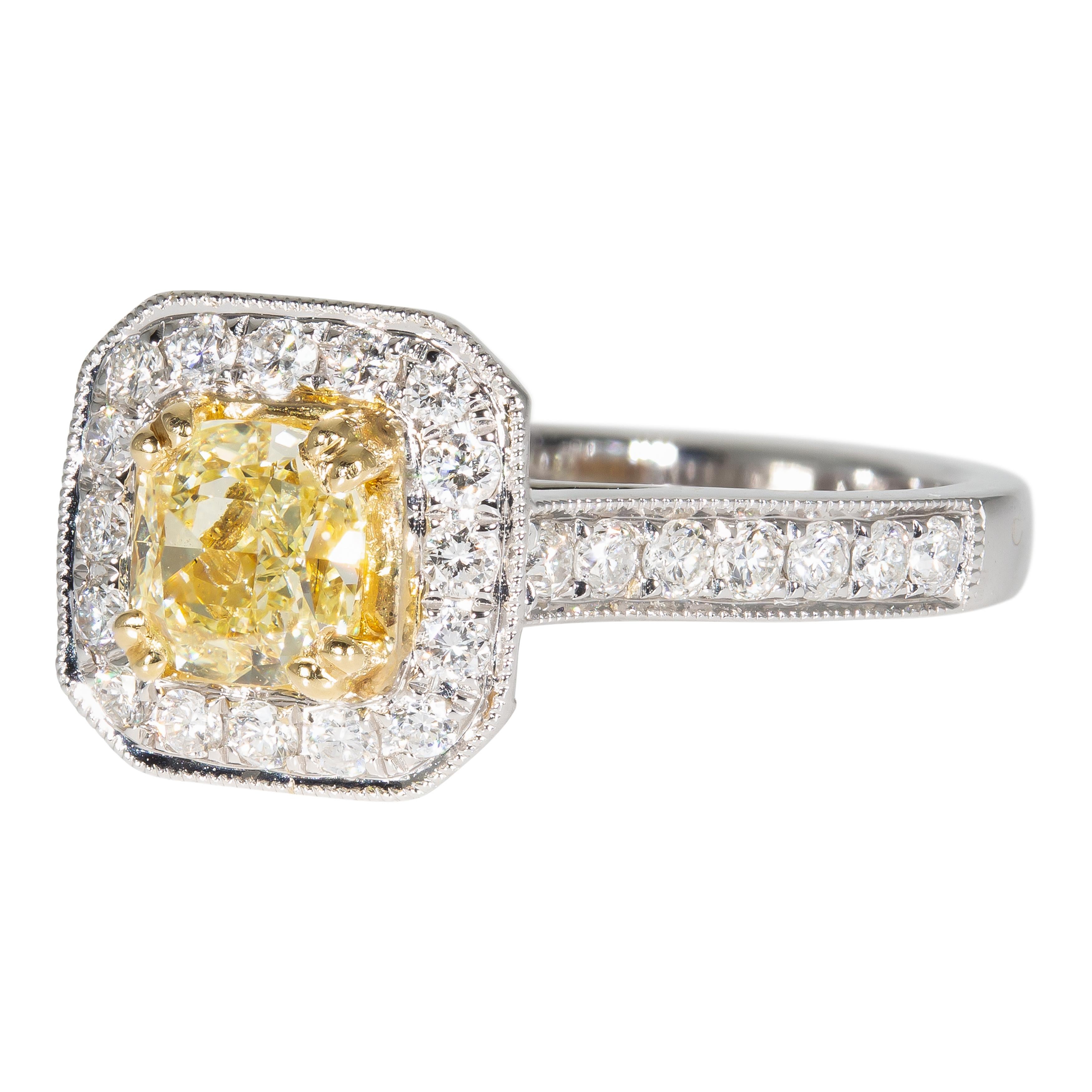 Beautiful 18 karat white gold ring with yellow gold accents containing a 0.71 carat prong set radiant brilliant natural diamond center stone with 42 pave set and two bezel set natural diamond side stones. The total weight of the 44 diamond side