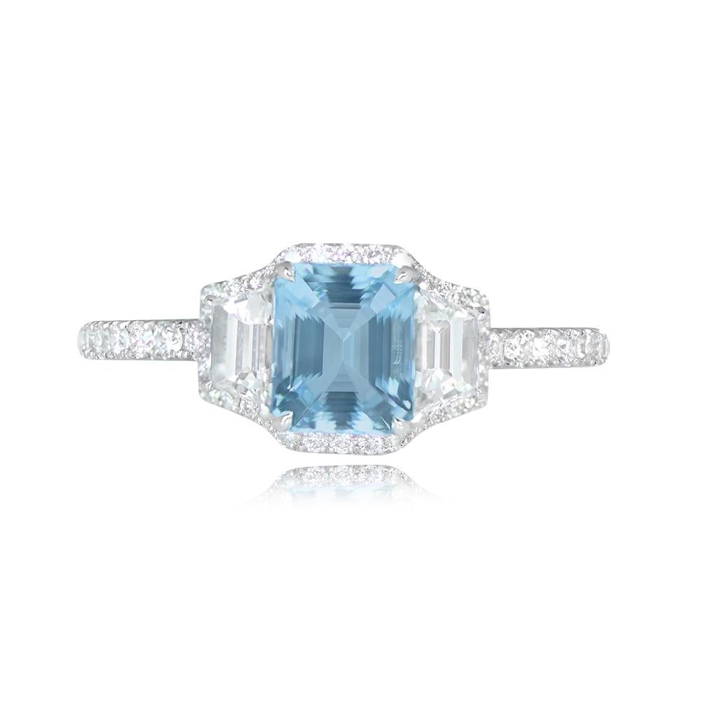 This ring showcases a 0.71-carat emerald-cut aquamarine set in prongs, accompanied by two trapezoid-cut diamonds weighing 0.39 carats. Micro-pave round brilliant-cut diamonds line the mount's border and shoulders, with a total weight of 0.31 carats.