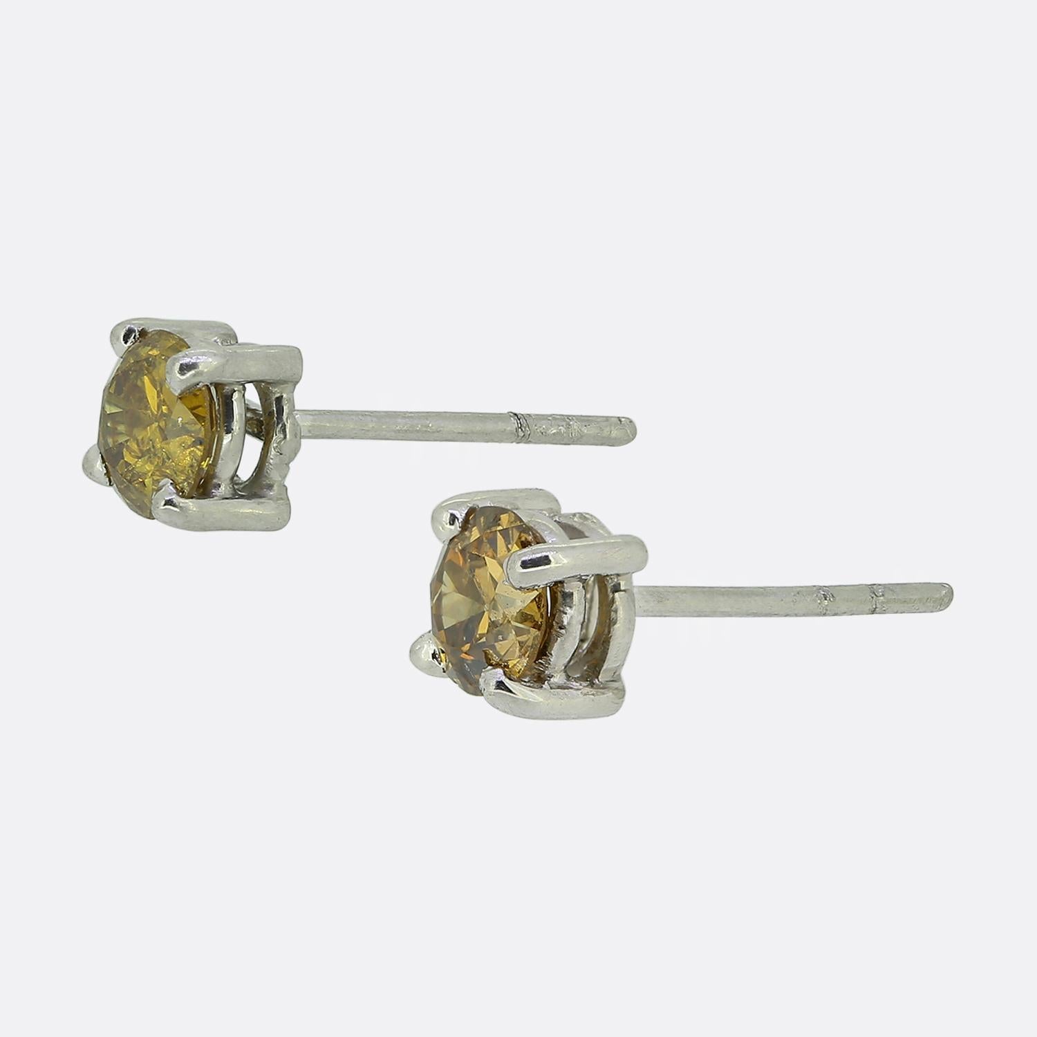 Nous avons ici une paire de boucles d'oreilles raffinées, chacune mettant en valeur un diamant naturel rond à facettes. Les pierres sont serties dans une monture classique à quatre griffes, le design minimaliste mettant en valeur leur captivante