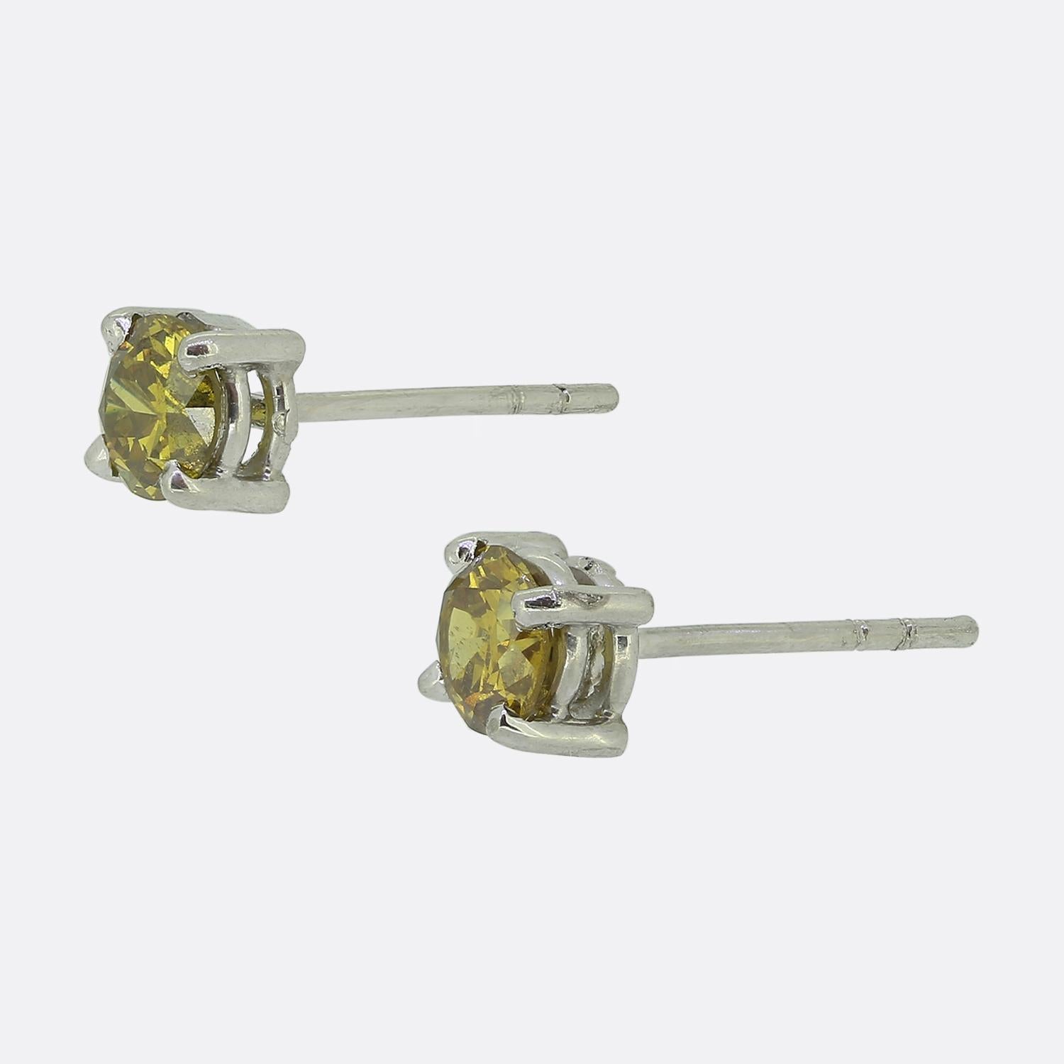 Nous avons ici une paire de boucles d'oreilles de style classique, chacune mettant en valeur un diamant naturel rond à facettes. Chaque pierre est sertie dans une élégante monture à quatre griffes, dont le design minimaliste met en valeur leur