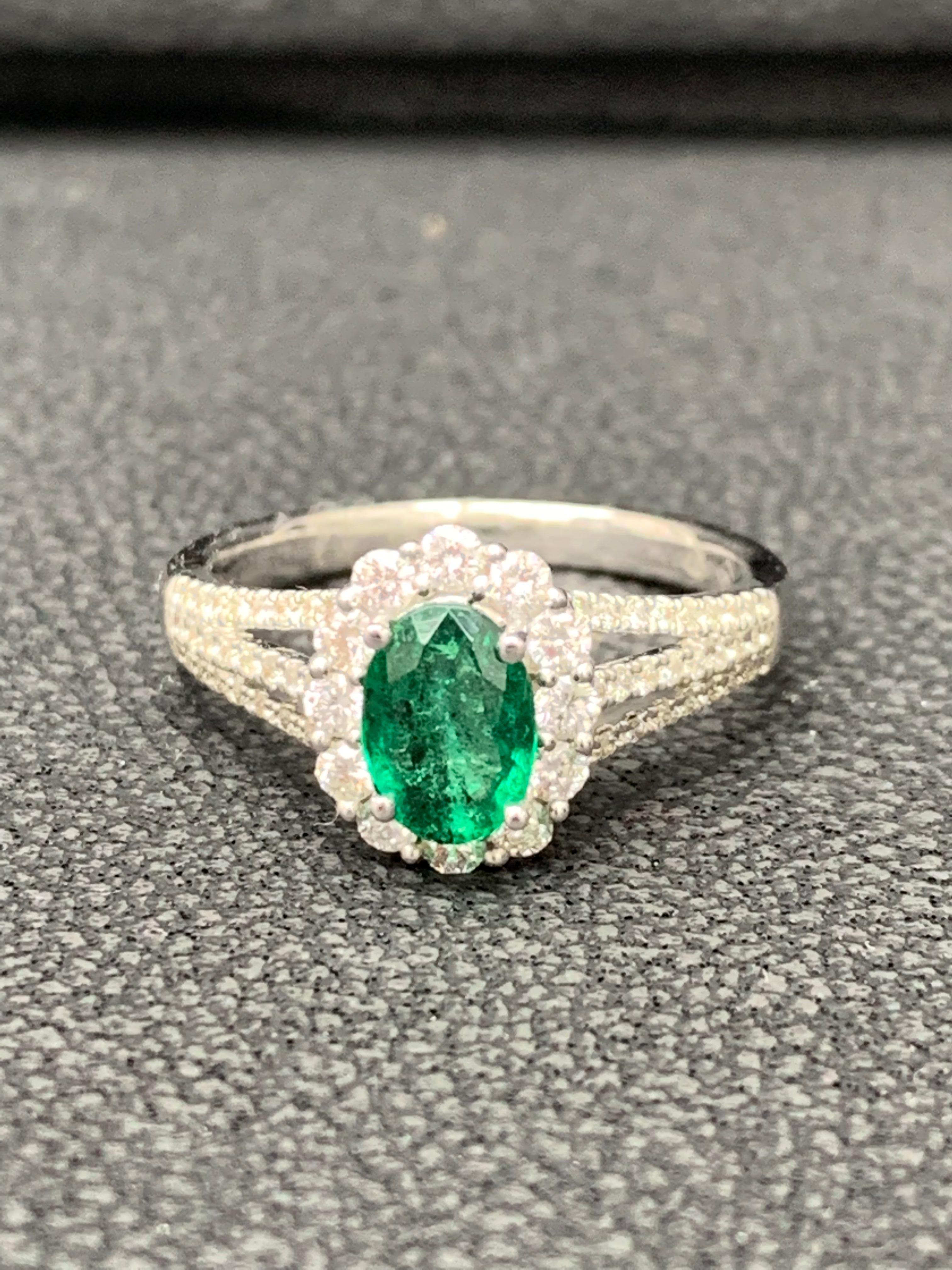 A beautiful and fashionable ring showcasing 0.73 Carat Oval cut Emerald surrounded by round brilliant diamonds, weighing 0.52 carat in total . Mounted in a 18k white gold split-shank setting  Size 6.5 US 