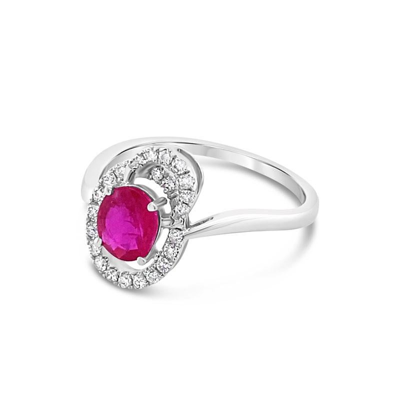 This is a very unique ring and features a 0.73 carat oval cut ruby surrounded by 0.17 carat total weight in round diamonds set in 18 karat white gold. This ring is a size 6.5 but can be resized upon request.