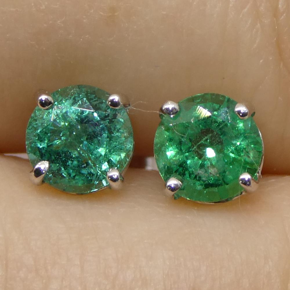 Cette exquise paire de boucles d'oreilles en émeraude verte ronde, totalisant 0,73 carats, est sertie dans de l'or blanc 14k avec des dos papillon. Fabriquées à la main à Toronto, au Canada, ces boucles d'oreilles sont d'une qualité exceptionnelle.
