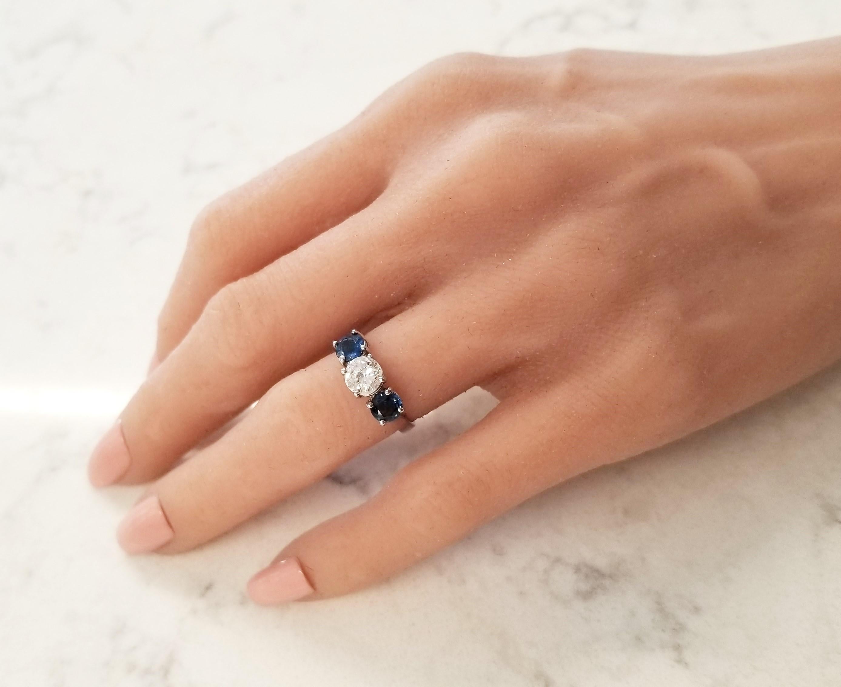 Looking for a classic 3 stone ring? This ring features a blazing and brilliant 0.74 carat round diamond in the center and a richly saturated blue sapphire sitting either side of the center. These sapphires are sourced from southern Madagascar. The