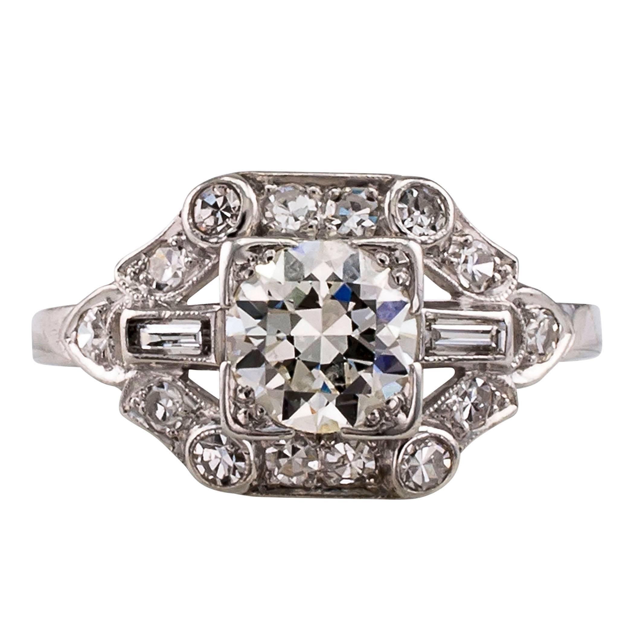 0.74 carat Art Deco 1930s diamond and platinum engagement ring. Centering upon an old transitional-cut diamond weighing approximately 0.74 carat, approximately J color and VS clarity, between baguette shoulders framed by smaller circular-cut