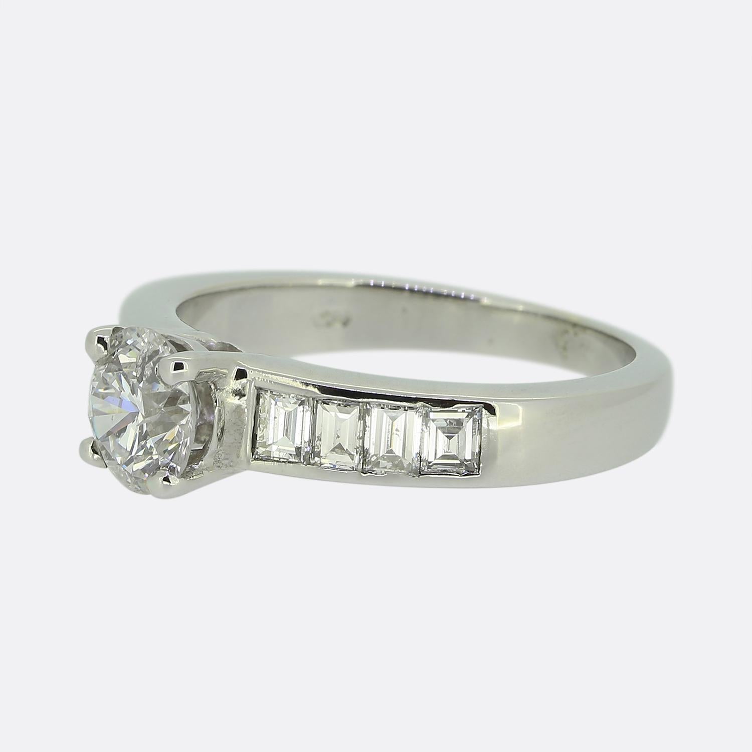 Whiting présente une bague de fiançailles en or blanc 18ct et diamant. Le point focal de cette pièce est un diamant rond de taille brillant de 0,74 carat qui trône fièrement dans une monture à quatre griffes. Chaque épaule est ensuite sertie de 4