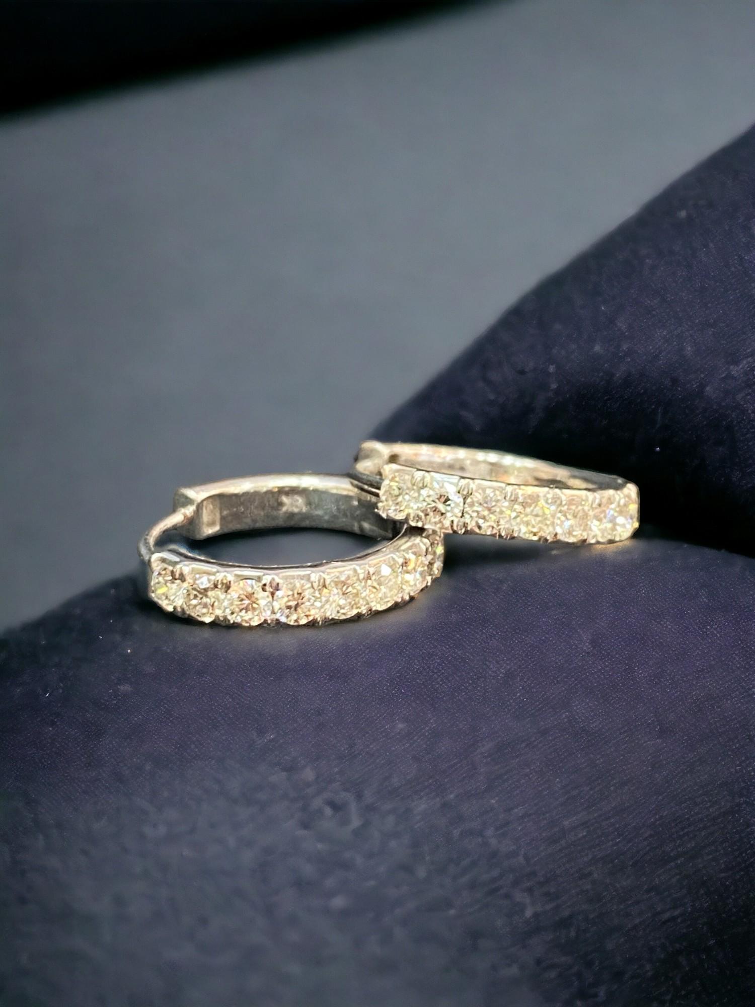 Ces boucles d'oreilles incarnent l'essence du glamour à l'état pur. Offrez-vous l'éclat éblouissant de ces boucles d'oreilles à un rang de diamants de 0,74 carat en or 18 carats, conçues pour vous faire sourire et rayonner à l'infini
