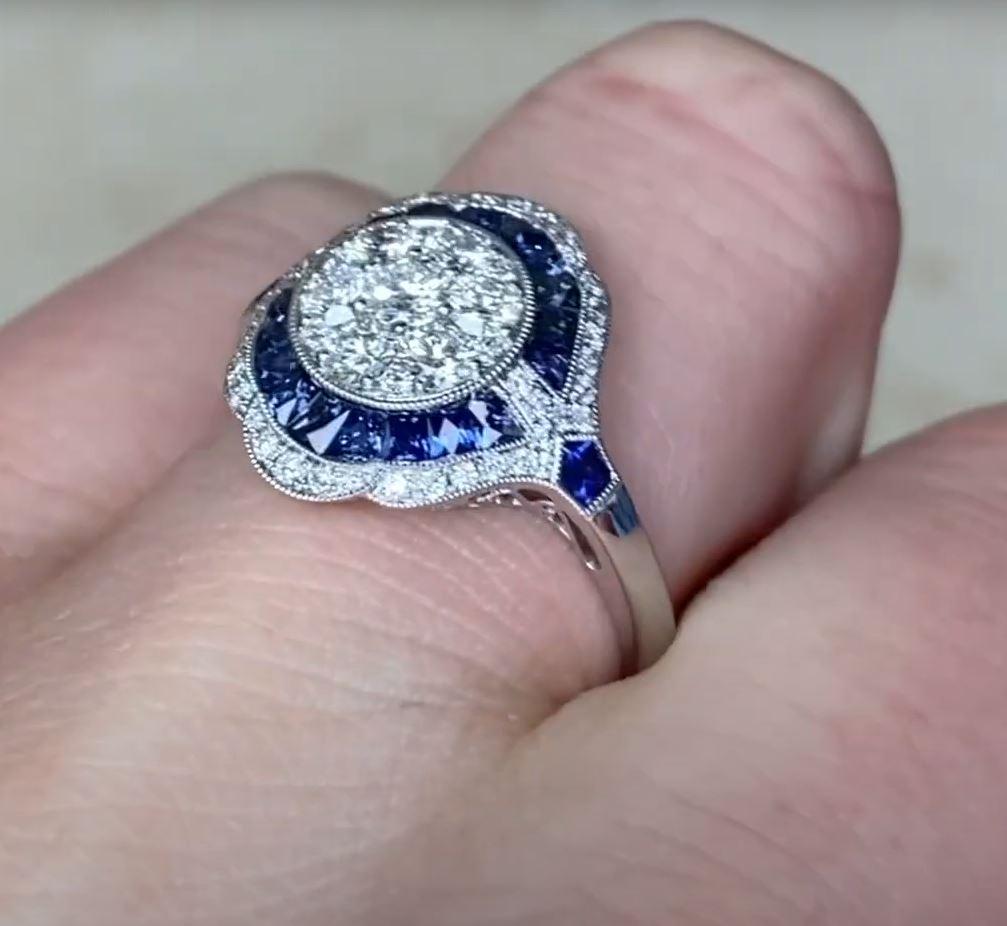 This exquisite Art Deco-style platinum ring is a testament to timeless elegance and masterful craftsmanship. At its heart, a dazzling cluster of round brilliant-cut diamonds catches the light, radiating brilliance with every movement. Surrounding
