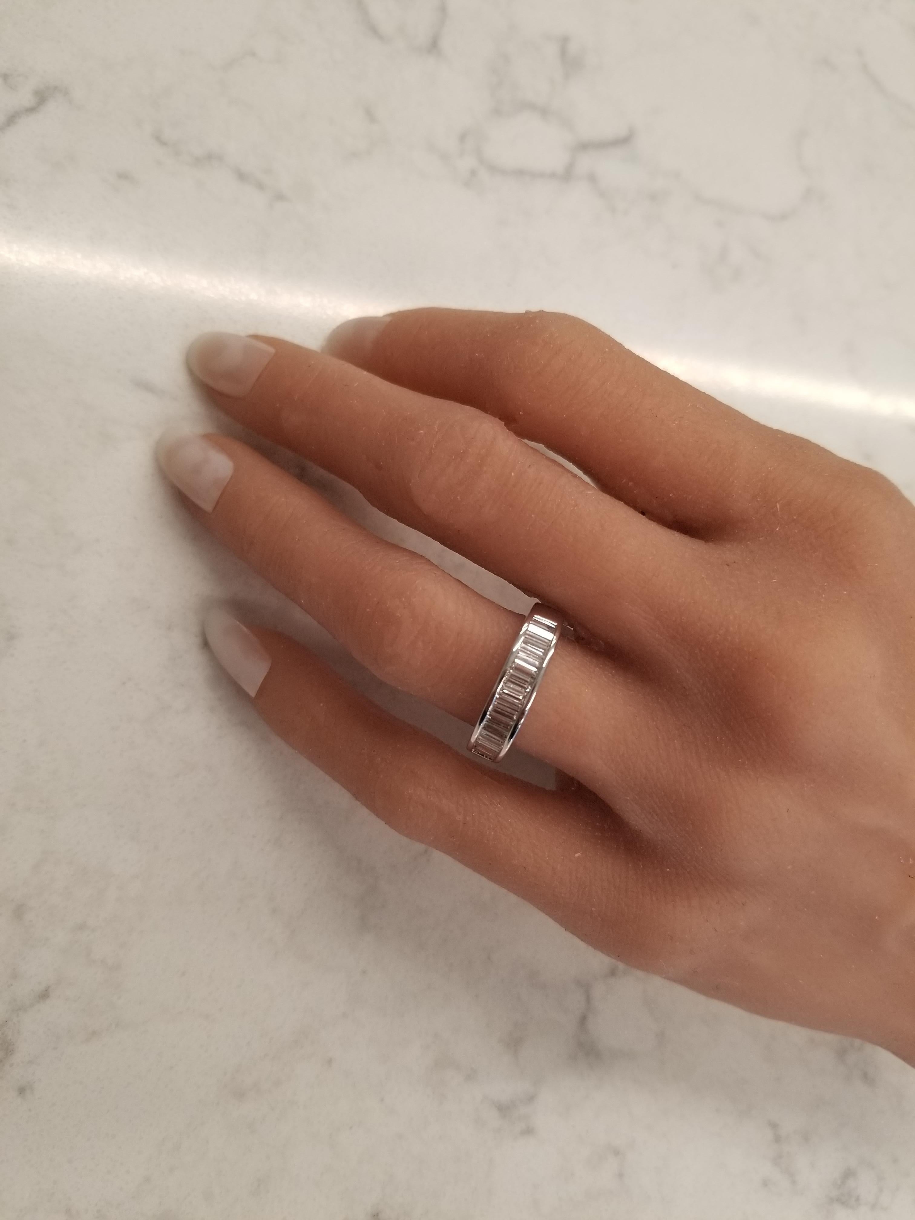 This brightly polished 14 karat white gold diamond wedding stackable ring exudes ultimate style and prestige with its incredible sparkle and fire. A total of 0.75carats of 20 shimmering baguette cut diamonds are arranged in a stunning row along the