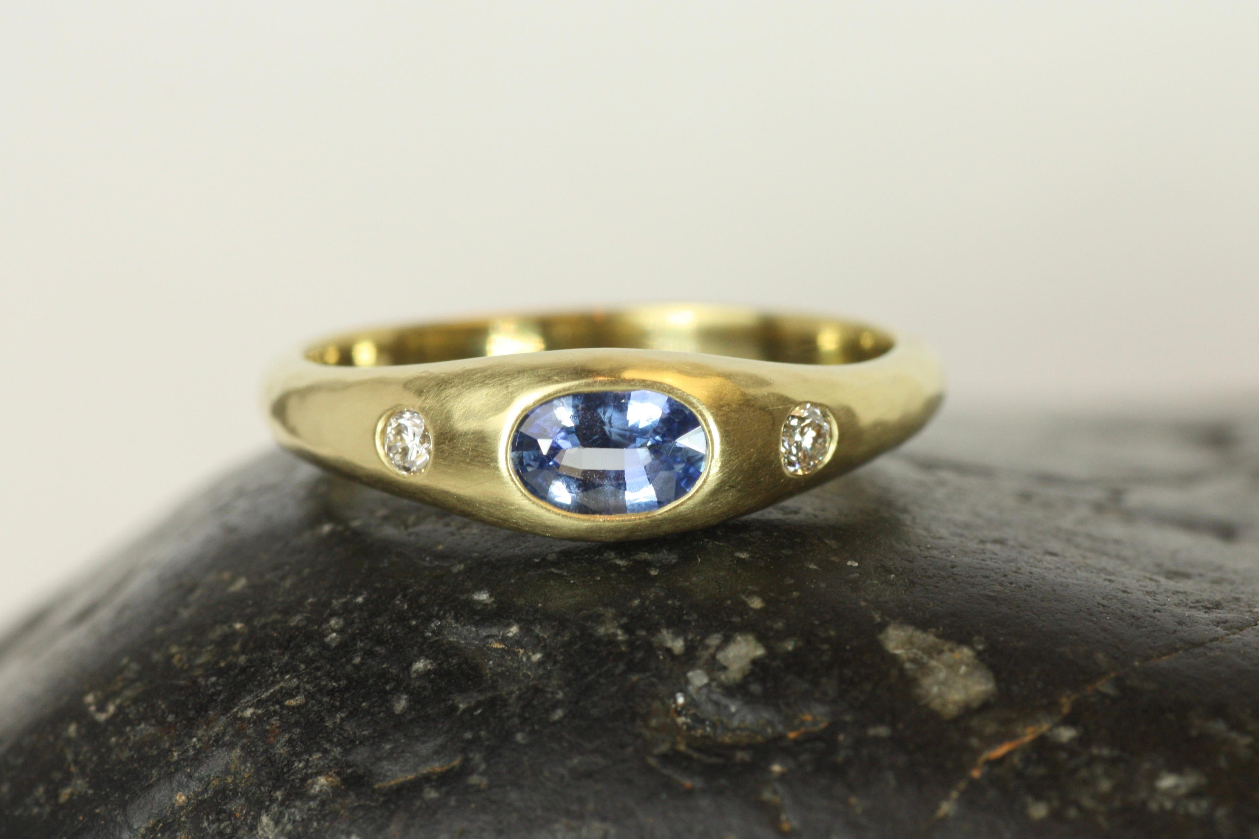 A vibrant 0.75ct Ceylon blue sapphire is the centerpiece of this handcrafted gypsy ring, flanked by two sparkling diamonds totaling 0.10ct. Set in 20K California gold, this unique design blends the rich heritage of traditional craftsmanship with a