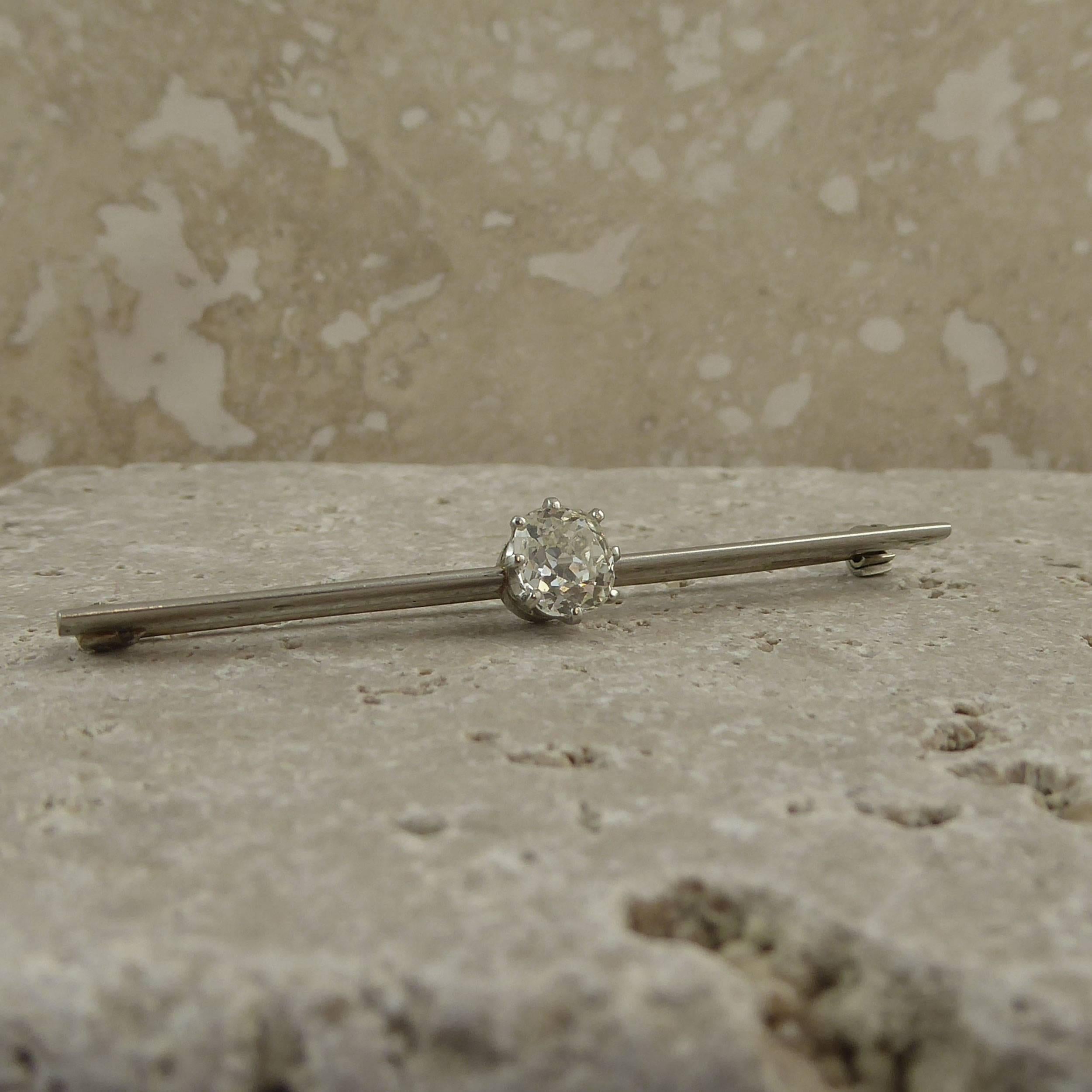 A diamond set bar brooch from the 1920s/1930s set to the centre with a cushion shaped old mine cut diamond in a white rex coronet mount.  The diamond has been calculated to weigh 0.75ct and has colour and clarity assessed as L/M and VS respectively.