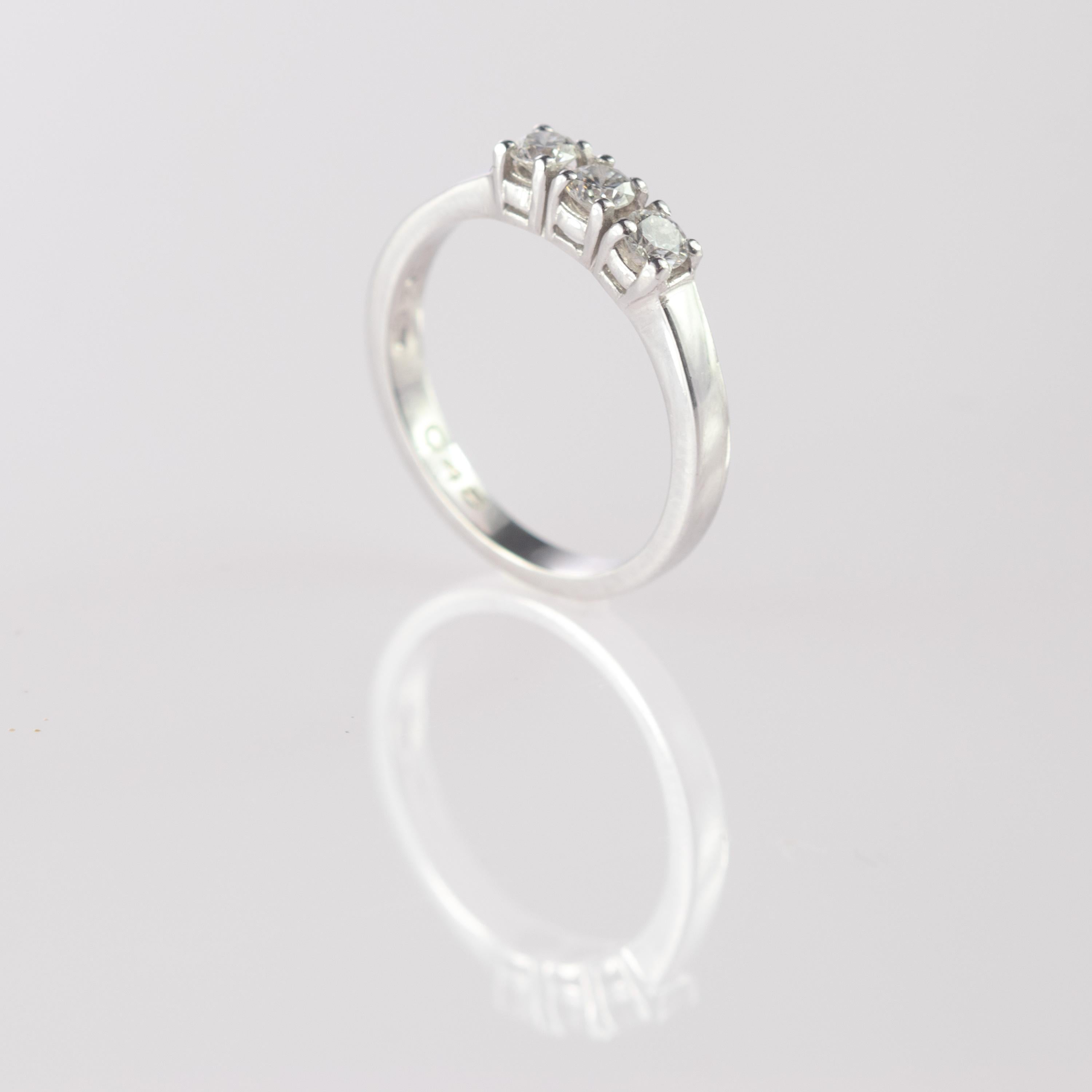 Étonnante et merveilleuse bague en diamant taille brillant embellie par de l'or blanc gravé 18 carats. Trois diamants pour un total de 0,75 carat créent une ligne de pierres précieuses travaillées avec soin pour être aussi délicates que le design de