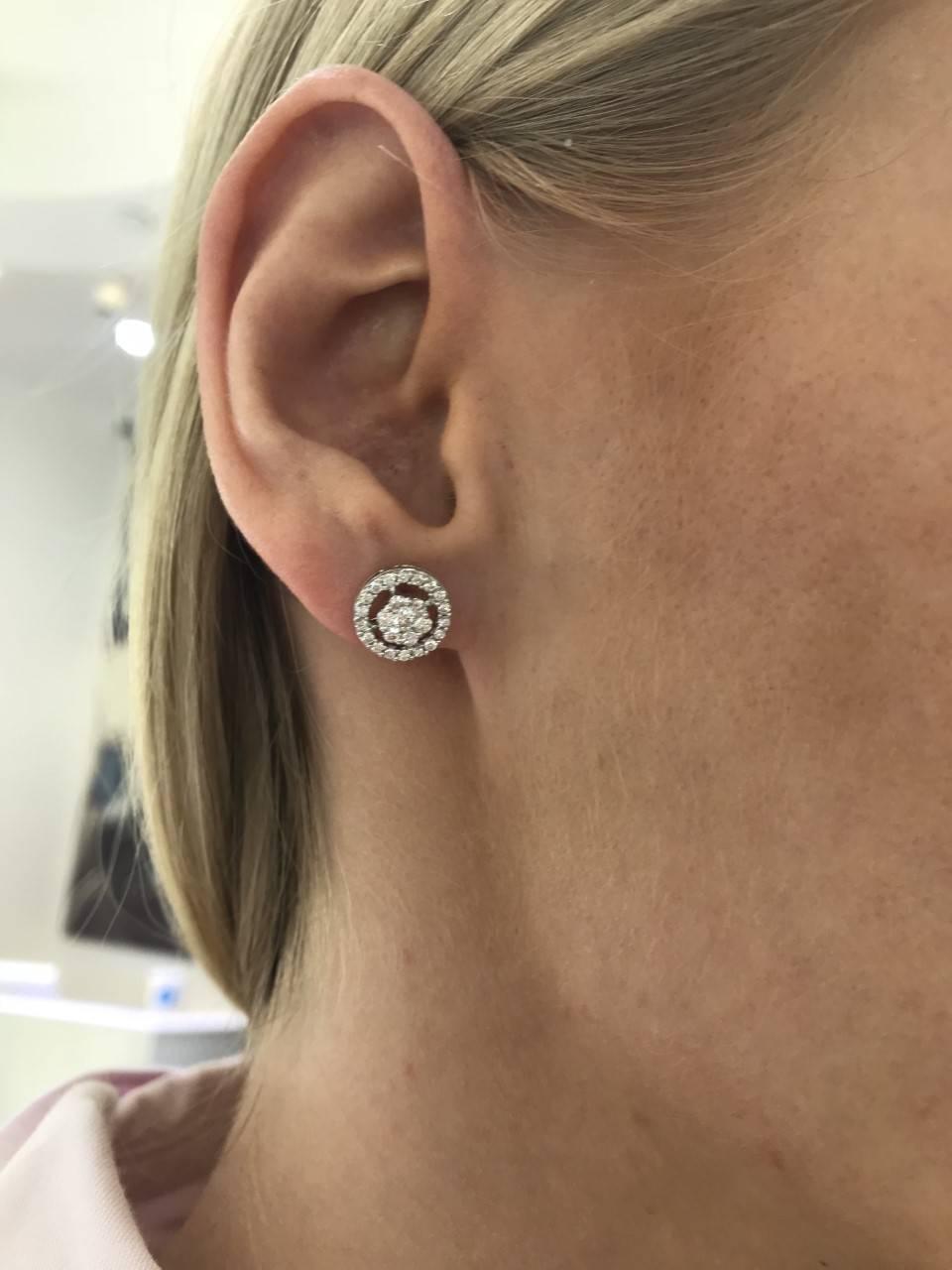 These eye catching sparkling Round Brilliant Diamond cluster stud earrings featuring H-SI Diamonds, set in 18 Karat White Gold. These mini cluster studs have an exquisite circular halo and a total diamond weight of 0.75 Carats and a measurement of