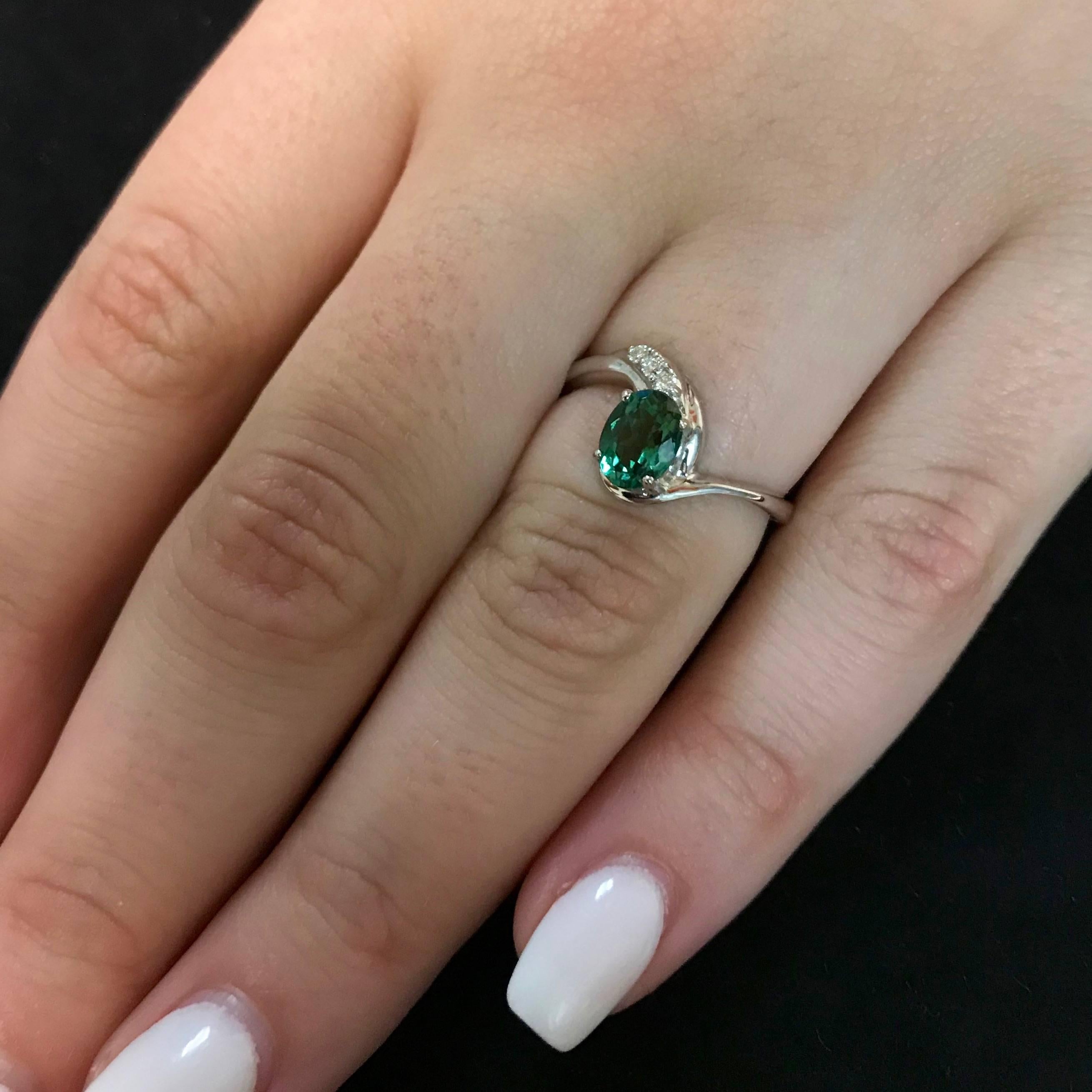 Material: 14k White Gold 
Center Stone Details: 0.75 Carat Oval Green Tourmaline 6.8 x 5 mm
Mounting Diamond Details: 3 Round White Diamonds Approximately 0.03 Carats - Clarity: SI / Color: H-I
Ring Size: Size 5.5 (can be sized)

Fine one-of-a kind