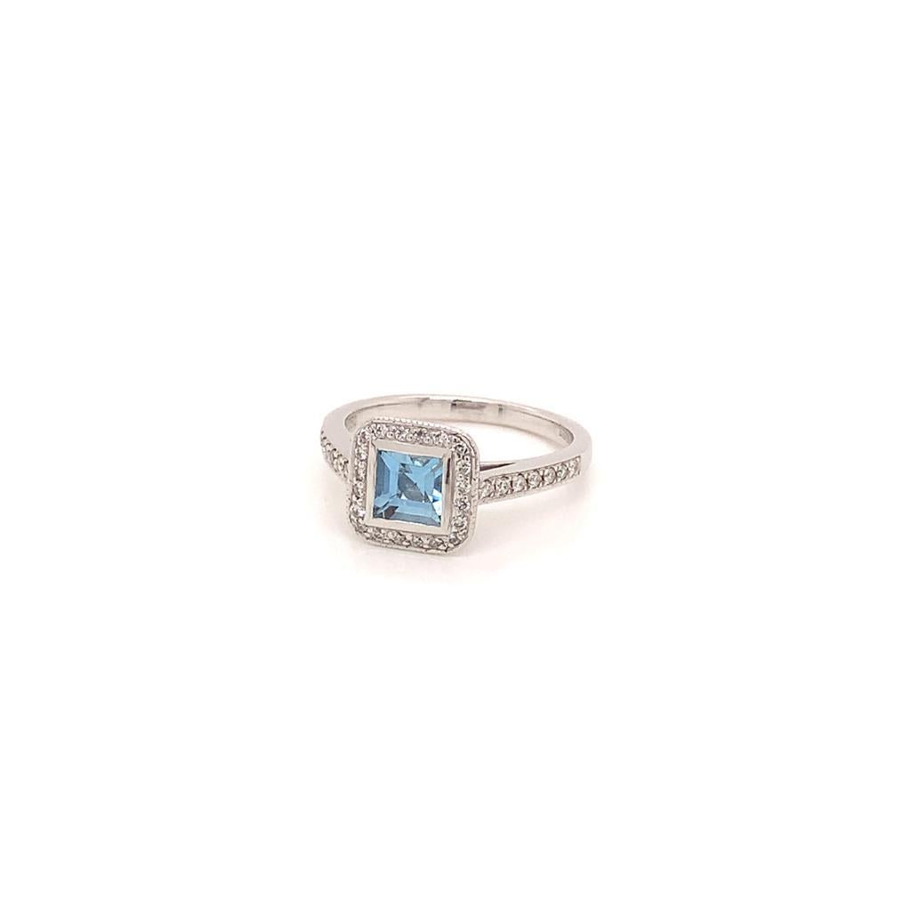 This dazzling ring features a princess cut ocean blue aquamarine weighing approximately 0.75 carats at its centre. This gorgeous stone is surrounded by a row of brilliant diamonds that extend to the 18k white gold band of this beautiful ring and