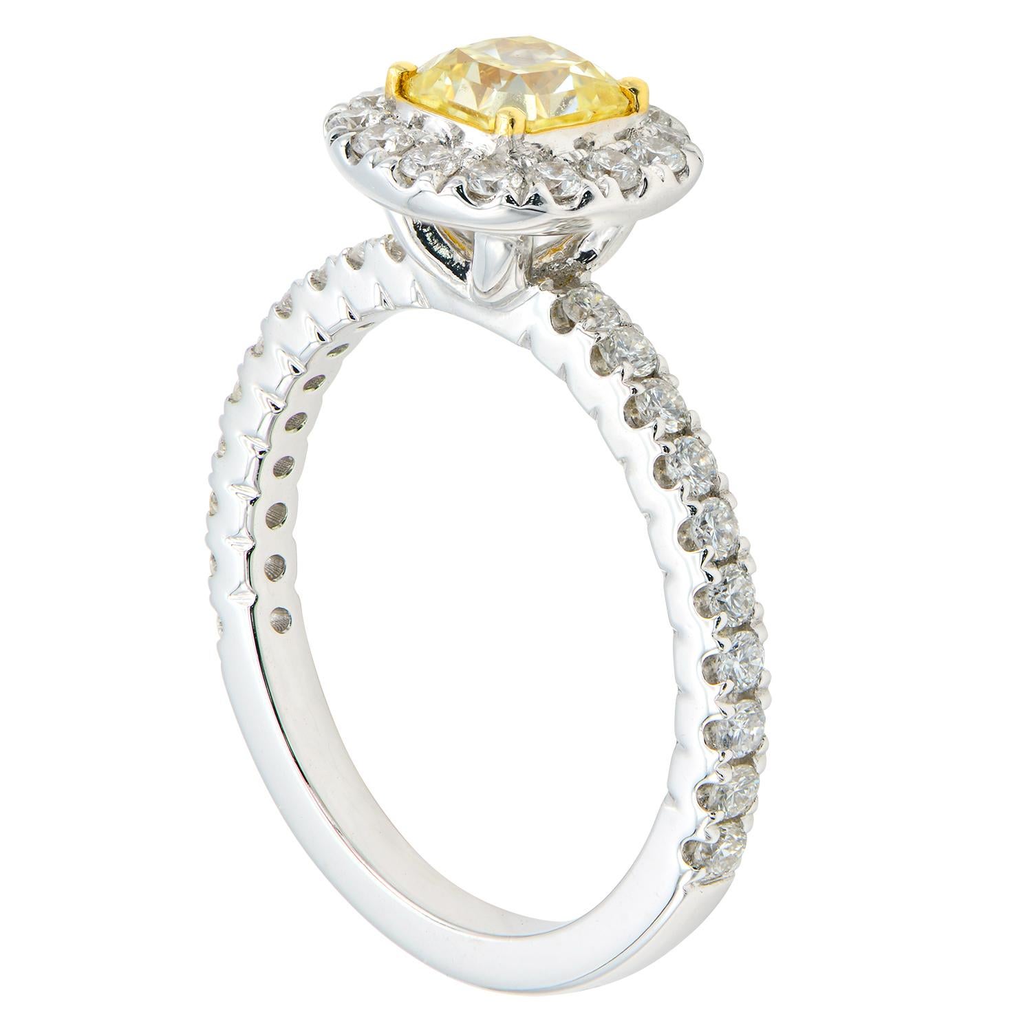This stunning diamond ring has a 0.75 carat yellow radiant cut diamond in the center which is surrounded by 14 VS2, G color diamonds in a halo with 20 more diamonds going halfway around the band. There is a total of 0.59 carats of white diamonds.
